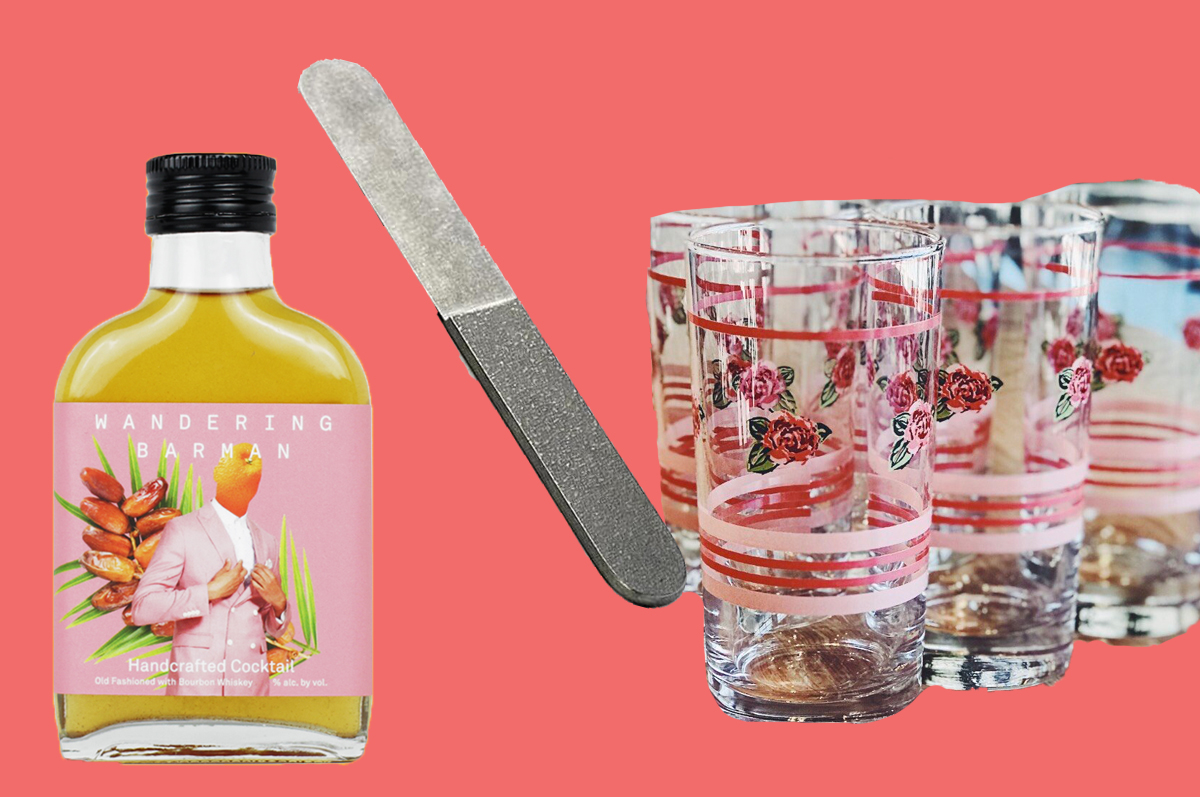 A small Wandering Barman bottle with yellow cocktail insider, a sleek metal butter knife, and a set of rose-and-stripe printed drinking glasses, all on a pink background