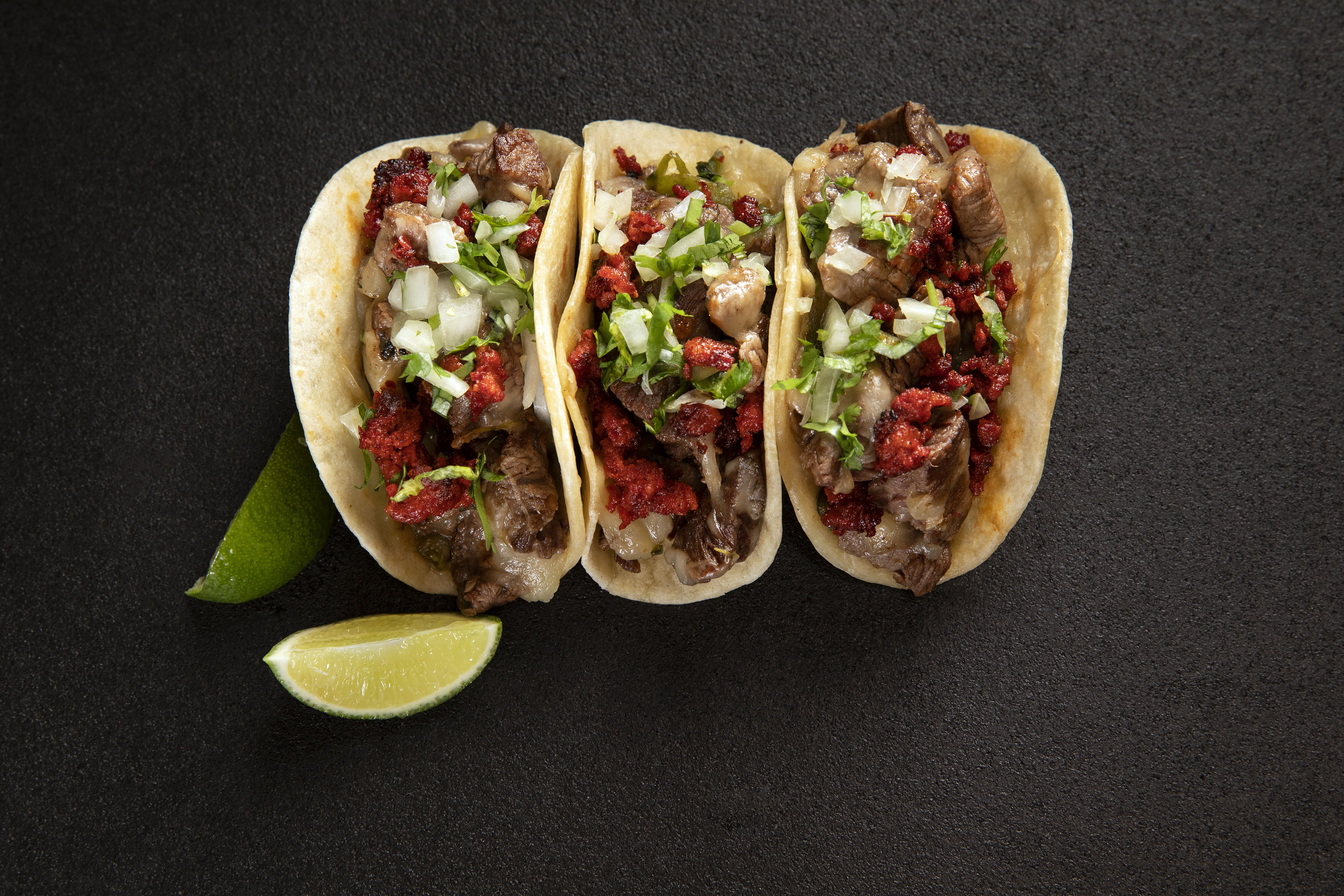 Three tacos on a black background