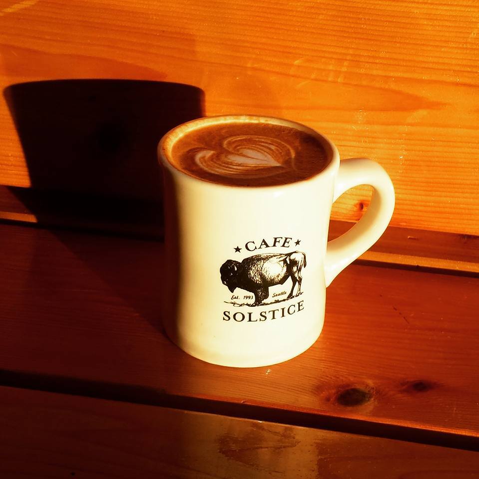 A closeup shot of a coffee mug with Cafe Solstice’s logo.