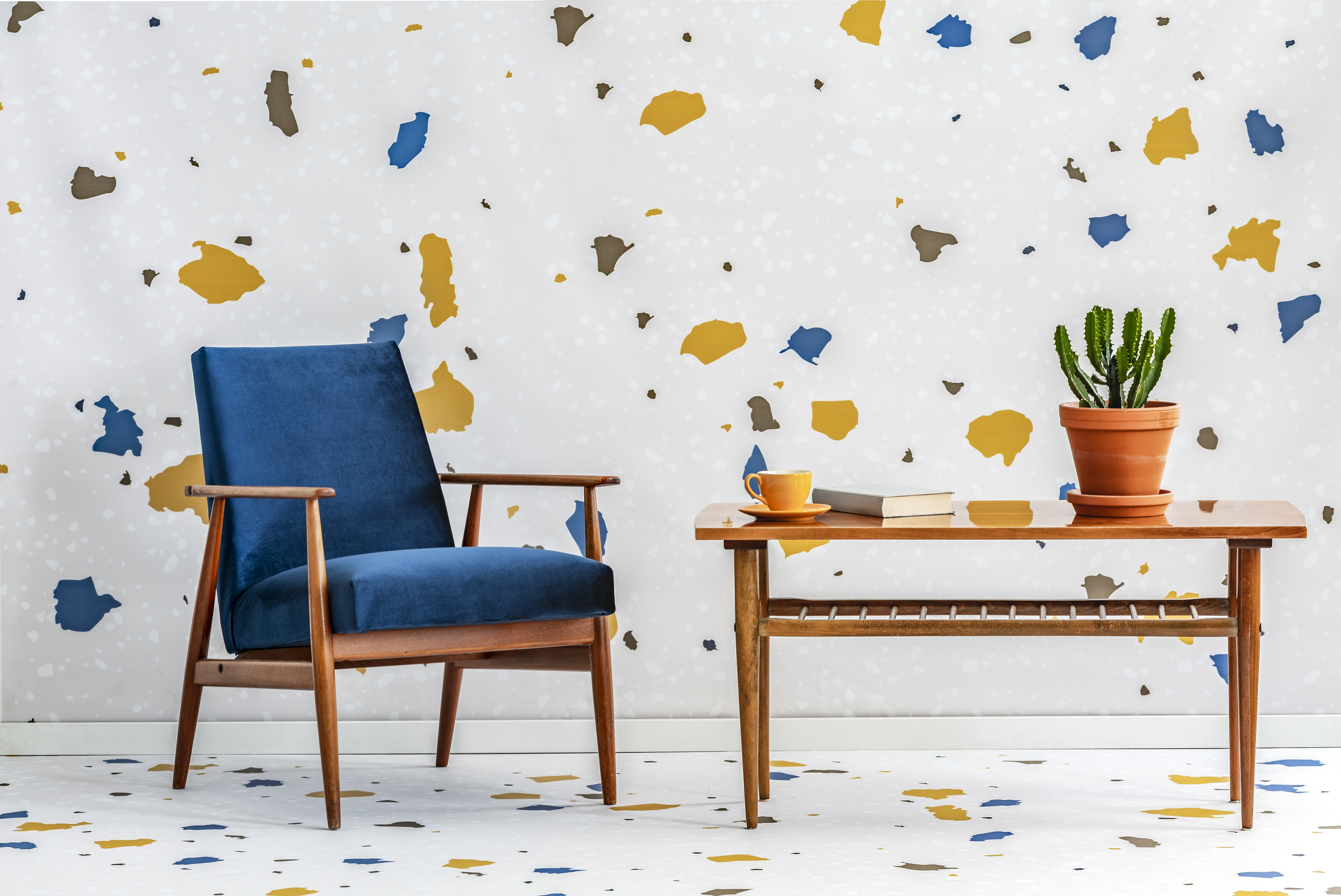 An armchair and side table on a terrazzo background and floor.
