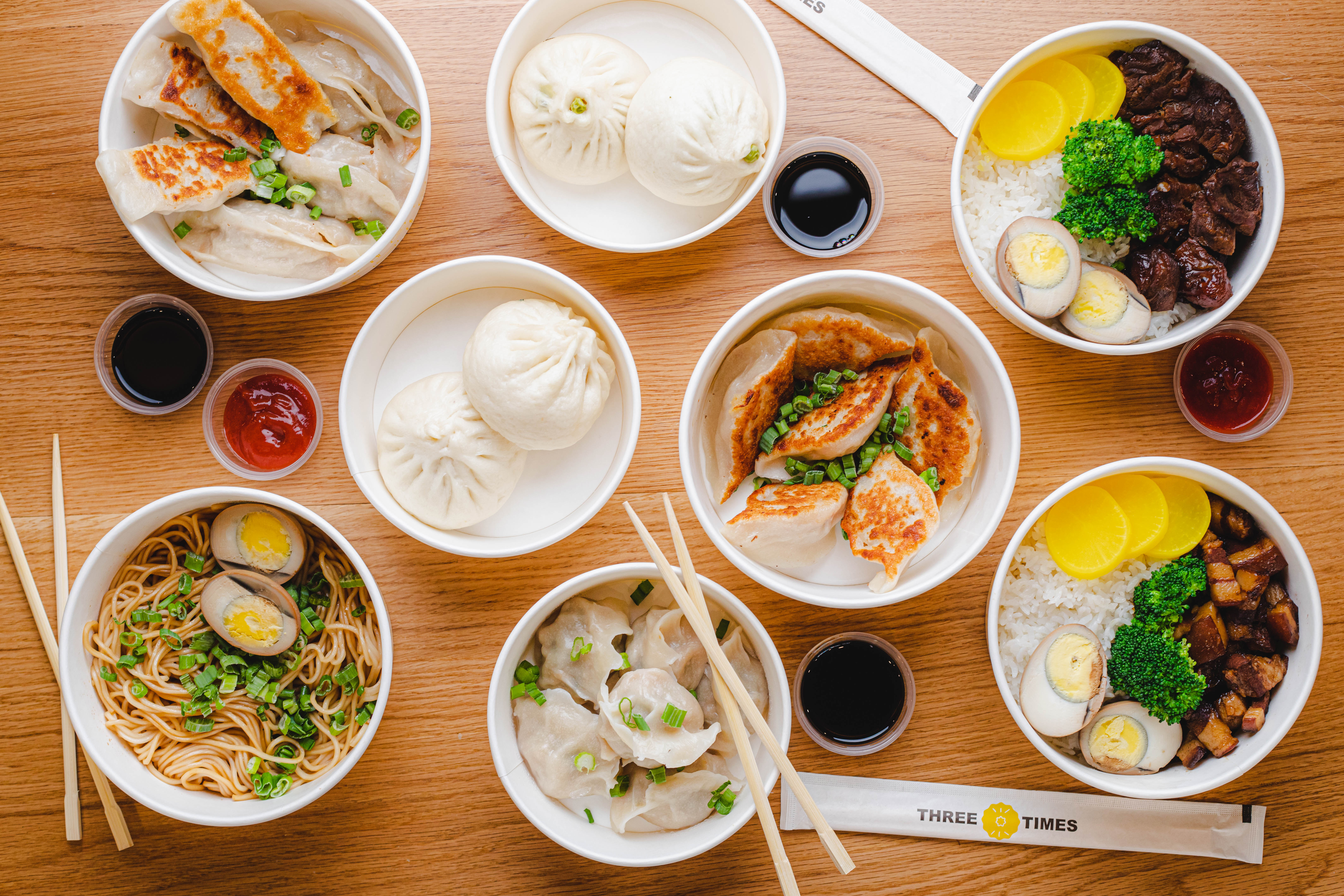 A spread of plated Chinese dishes like noodles and dumplings