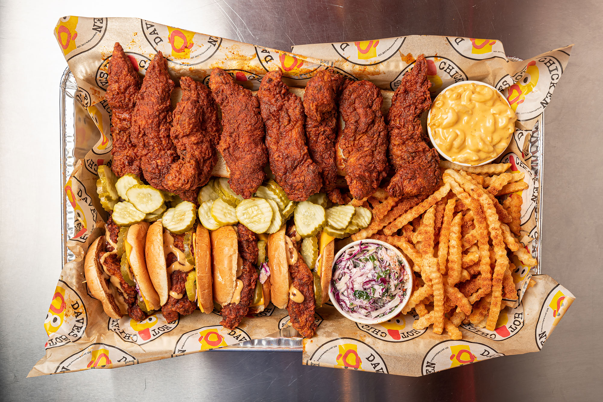 A lineup of chicken tenders and sandwiches with fries and sides.