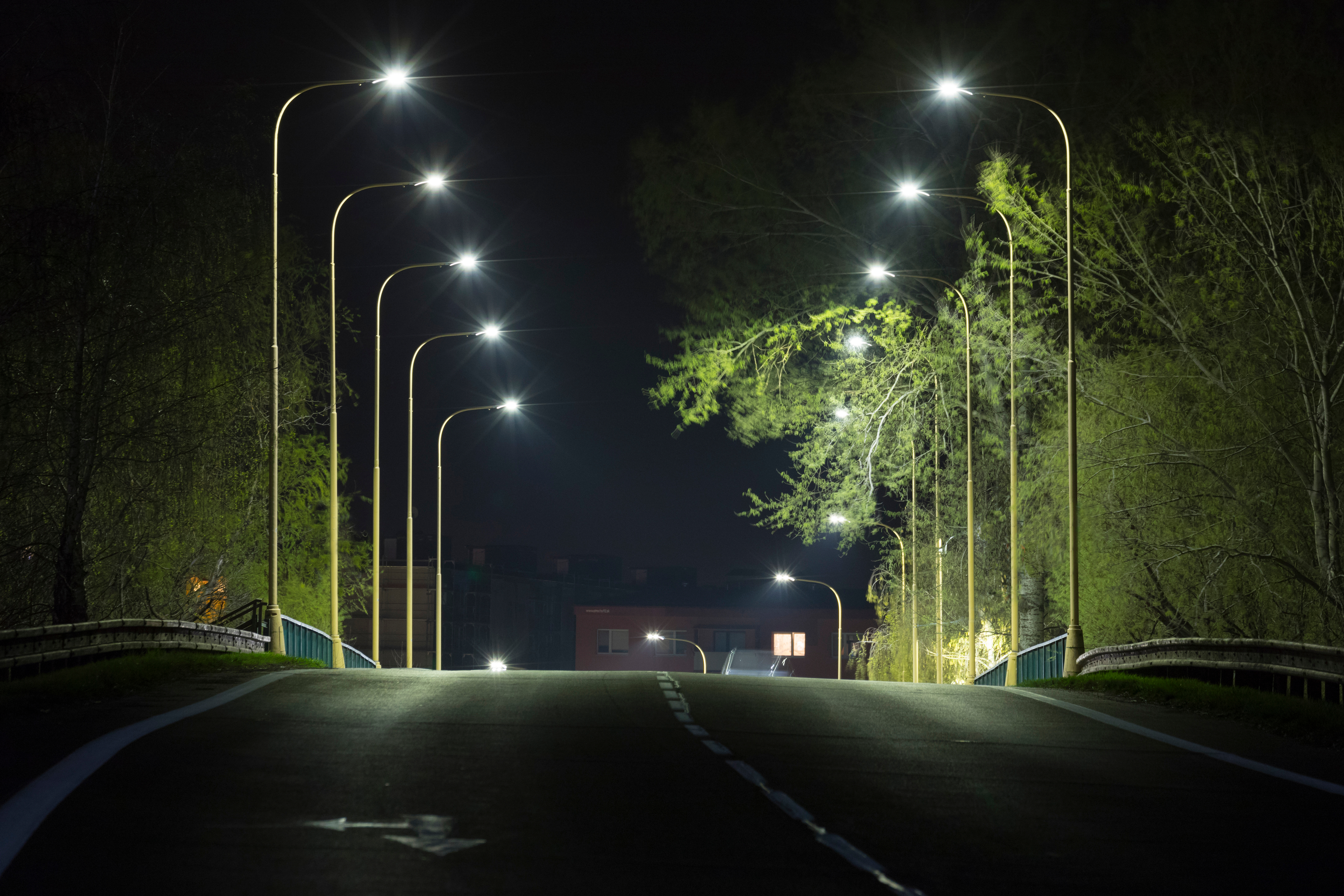 Two rows of LED streetlights on either side of a road at night.
