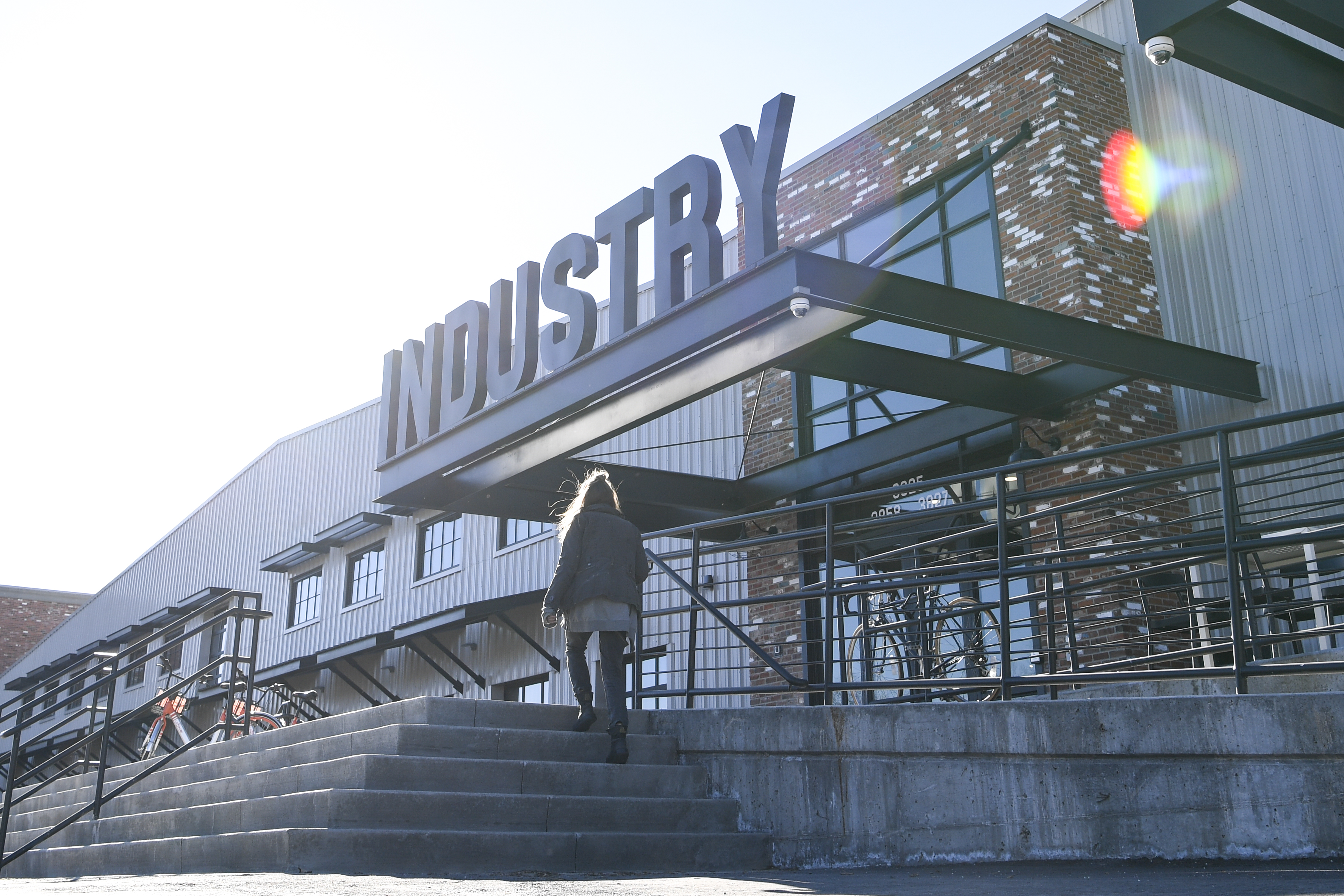A photo of the exterior of the Industry Building in RiNo, with steps leading up to the building and large signage spelling out “Industry” visible