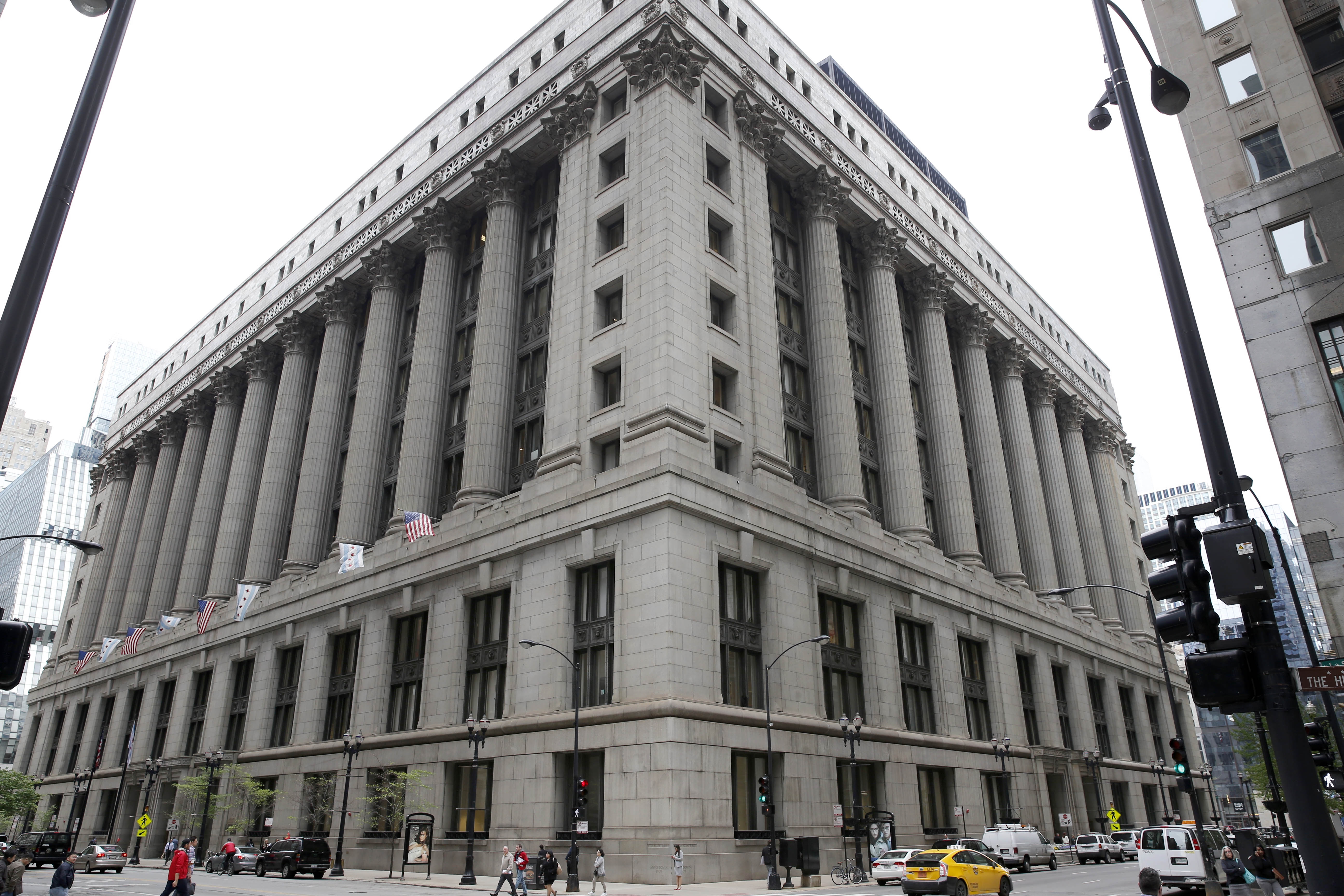 Photo shows the exterior of Chicago’s City Hall in Chicago which has grey stone, large columns, and windows.