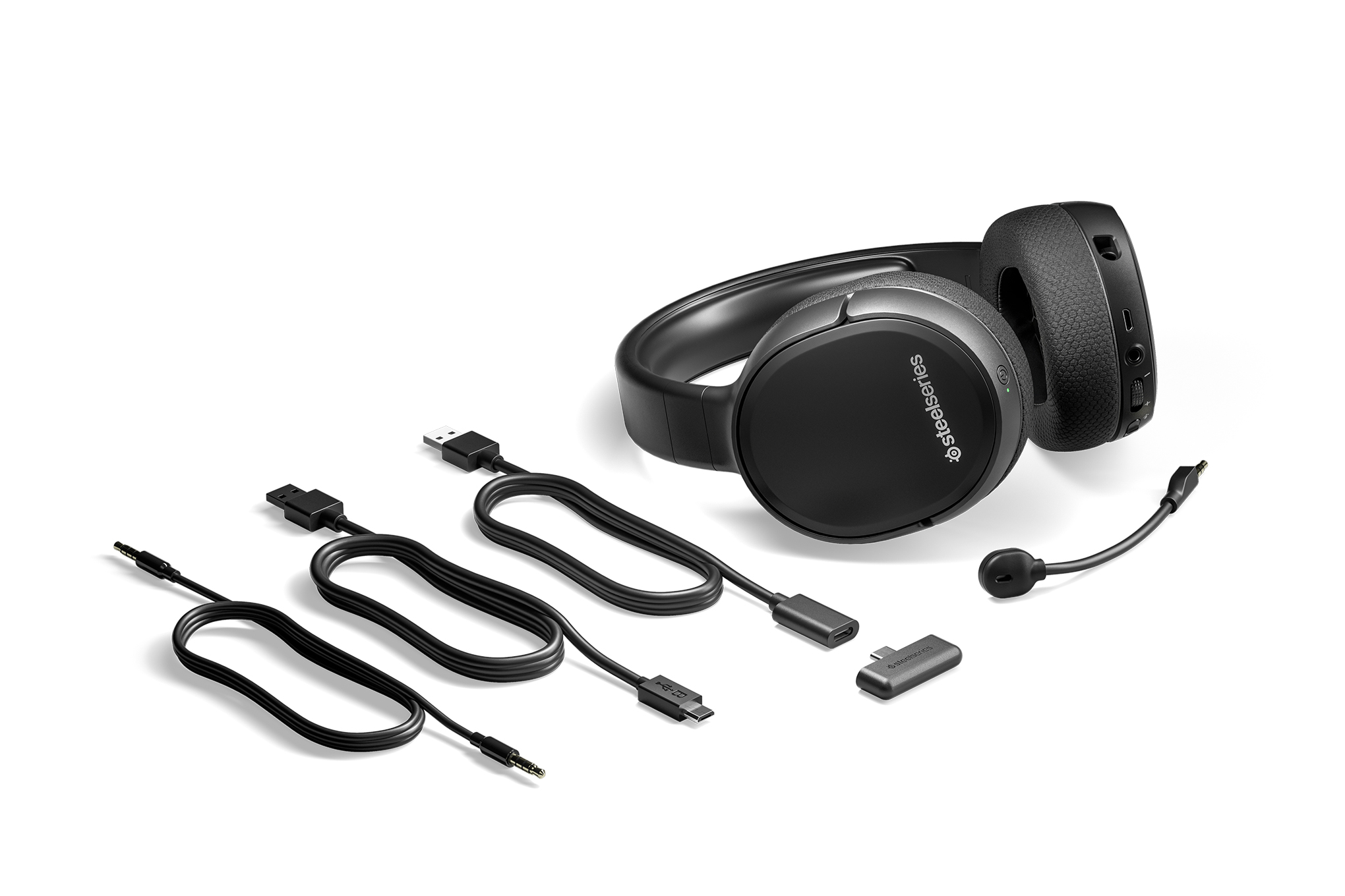 The SteelSeries Arctis 1 Wireless with its various accessories splayed out around it.