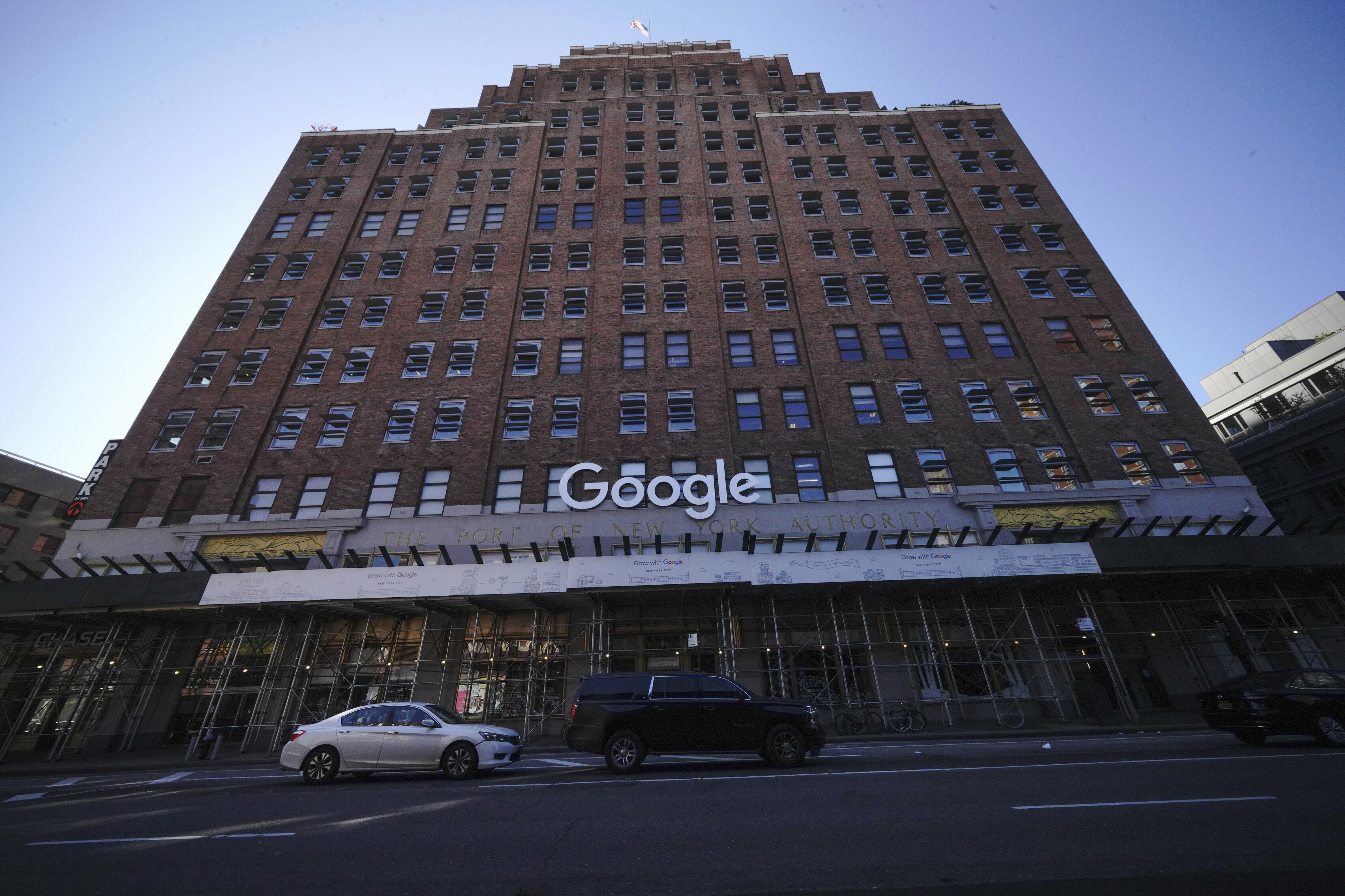 A high-rise brick building with a bright white “Google” sign on the facade.