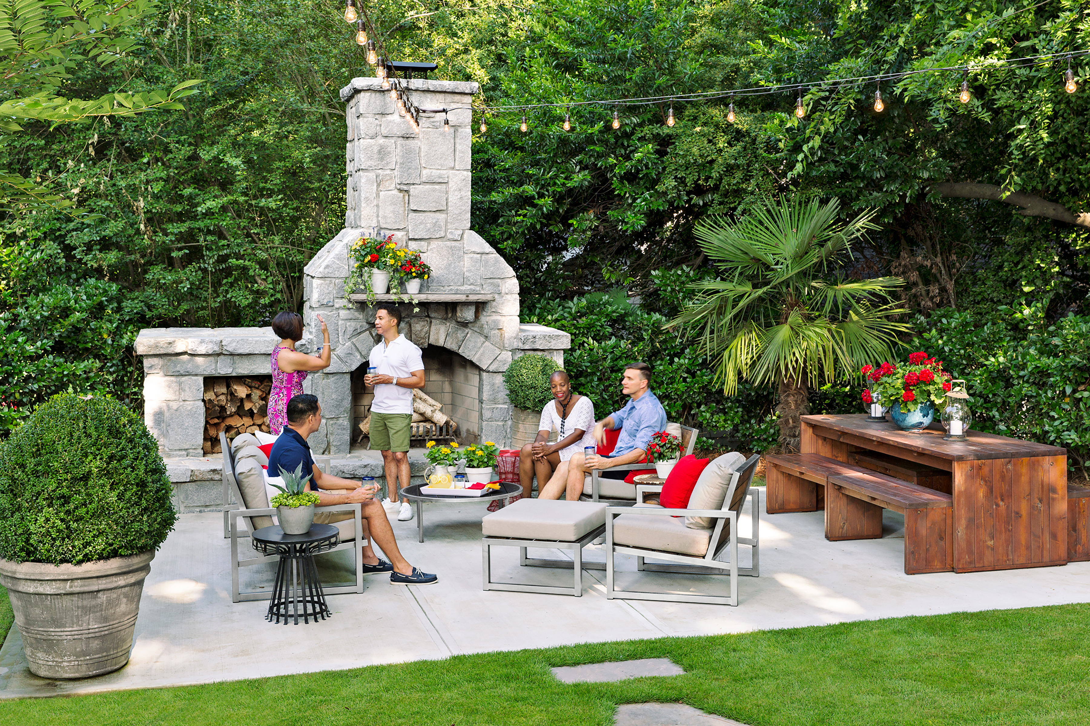 Group of friends in backyard patio in front of fireplace