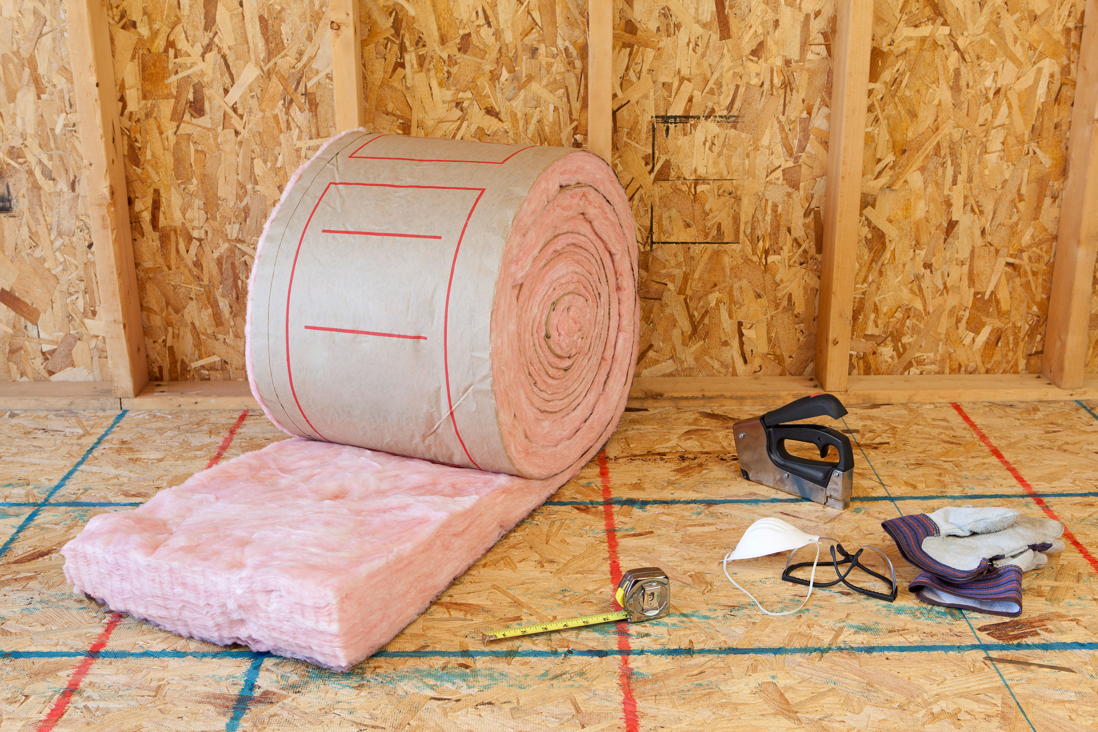 Roll of fiberglass insulation in an unfinished room. 