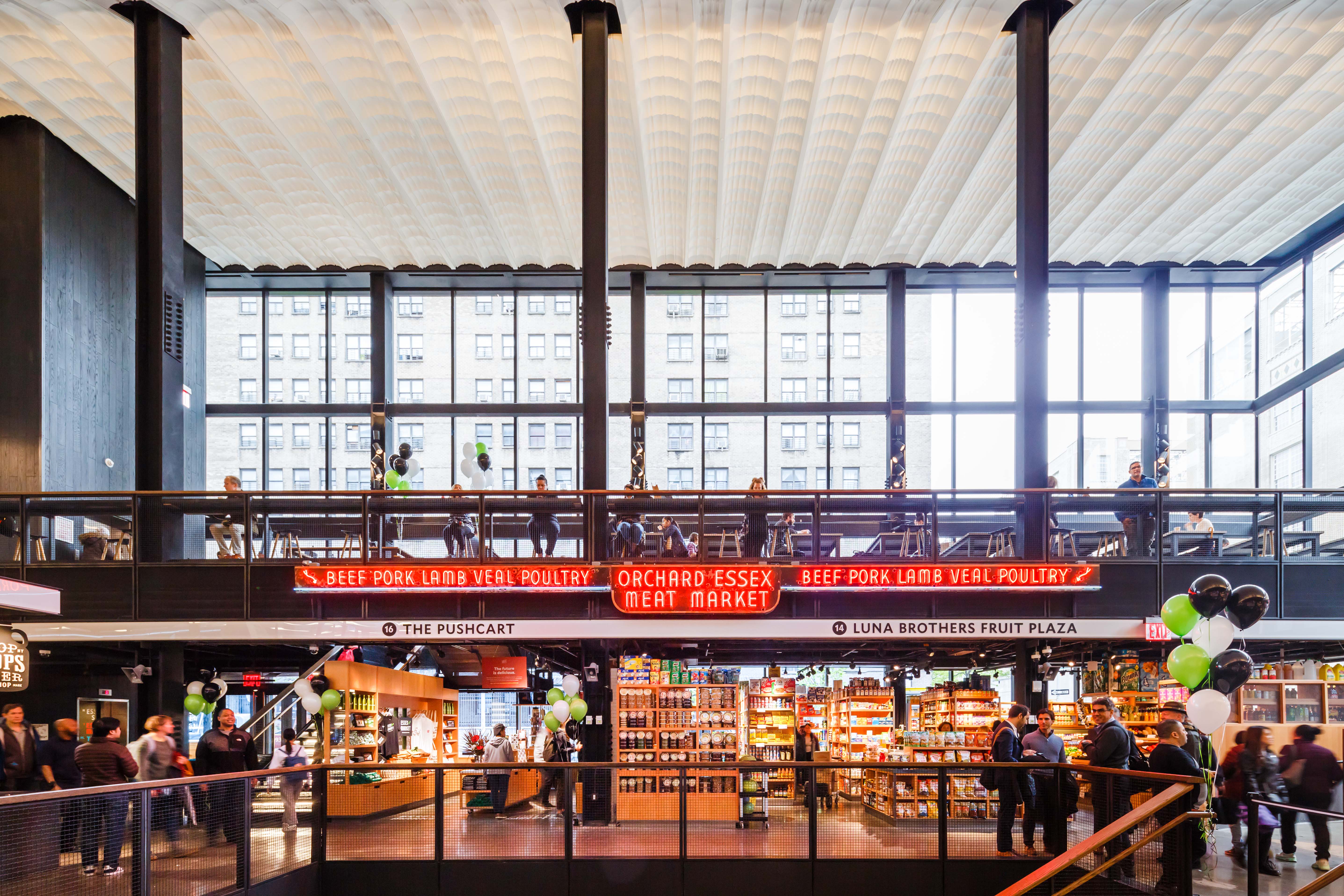 A huge food hall with floor-to-ceiling windows and a top floor of dining area