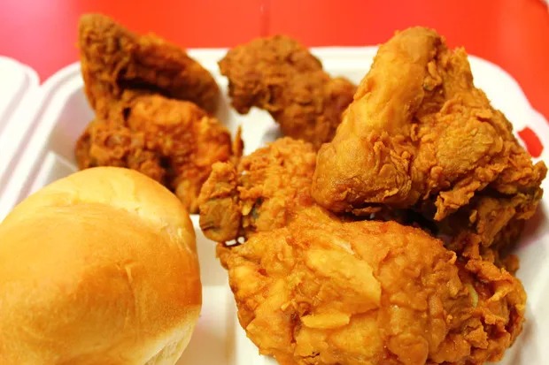 A picture of several pieces of Ezell’s chicken and a roll in a styrofoam container. 
