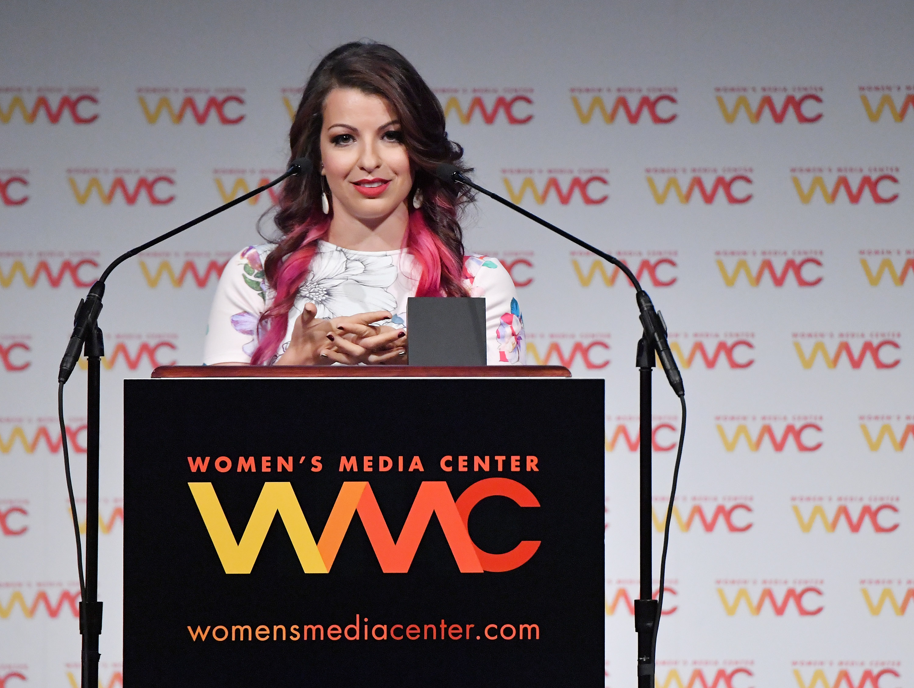 Anita Sarkeesian behind a podium at the Women’s Media Center