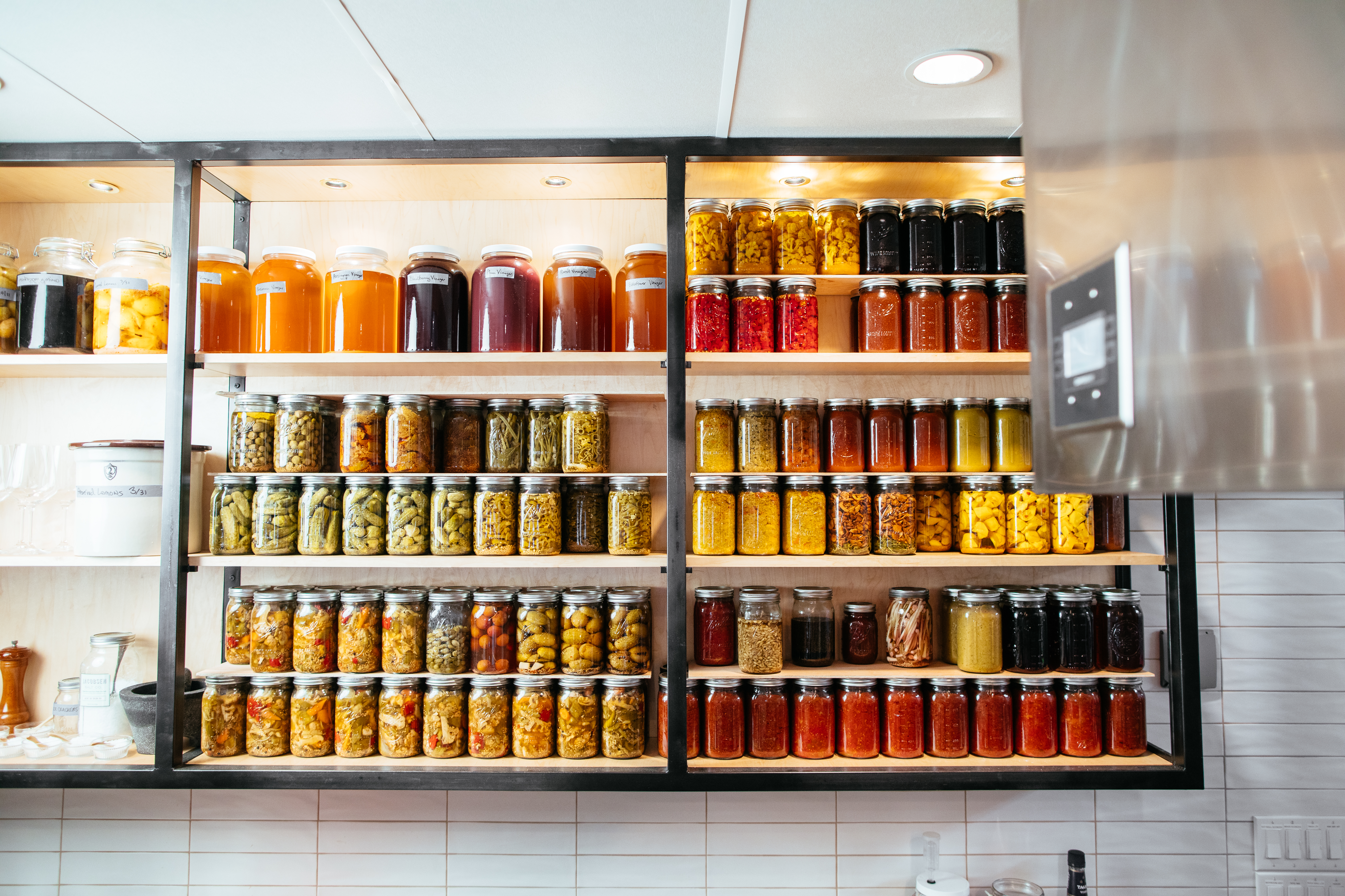 Jars of fermented, canned, and preserved ingredients at Homewood in Dallas