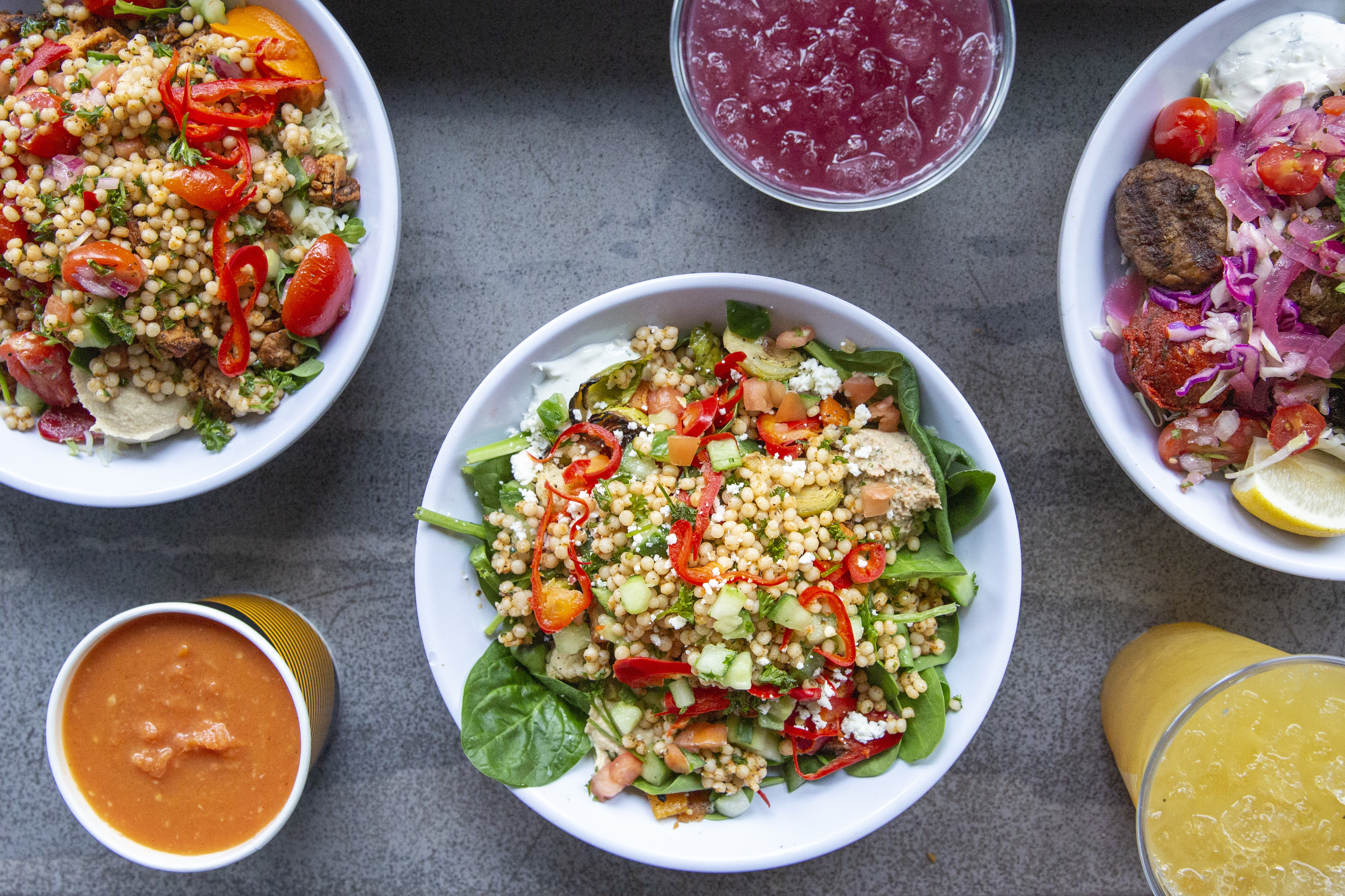 An overhead photograph of several bowls and sides from Cava, a Mediterranean-ish fast-casual restaurant in New York City.