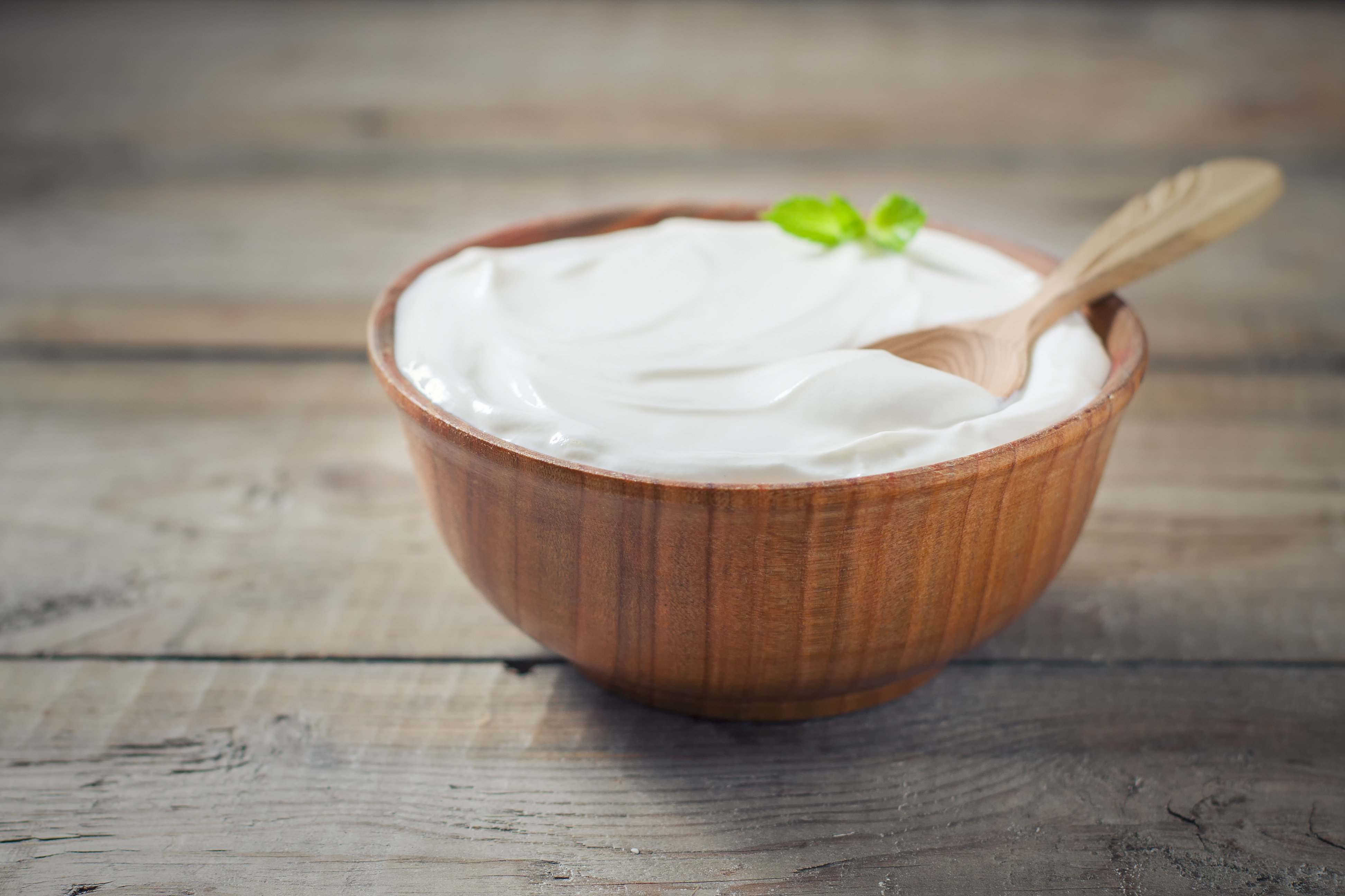 A bowl of yogurt on a wooden table. 