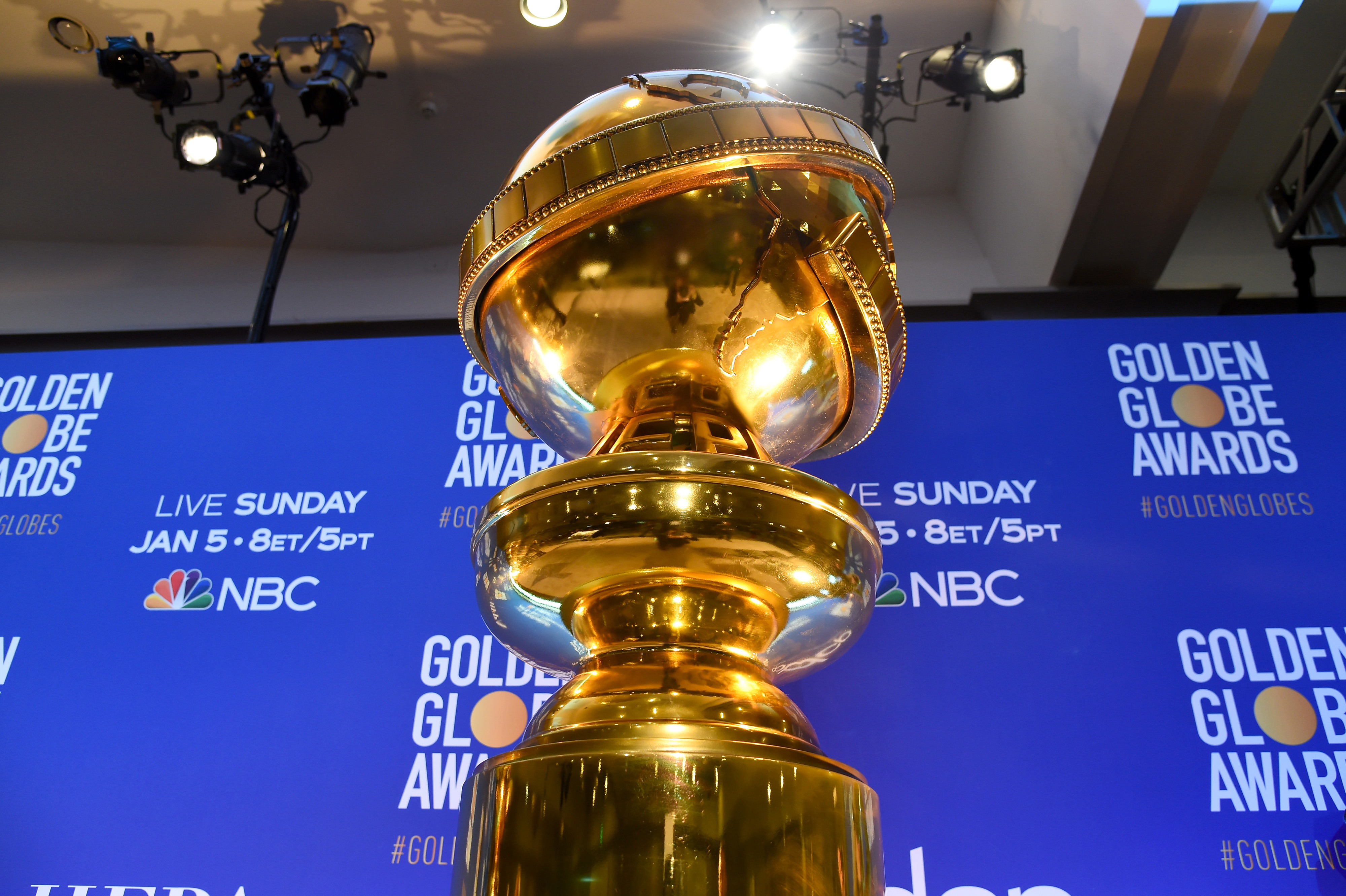 A Golden Globe statue in front of a backdrop that reads, “Golden Globe Awards.”