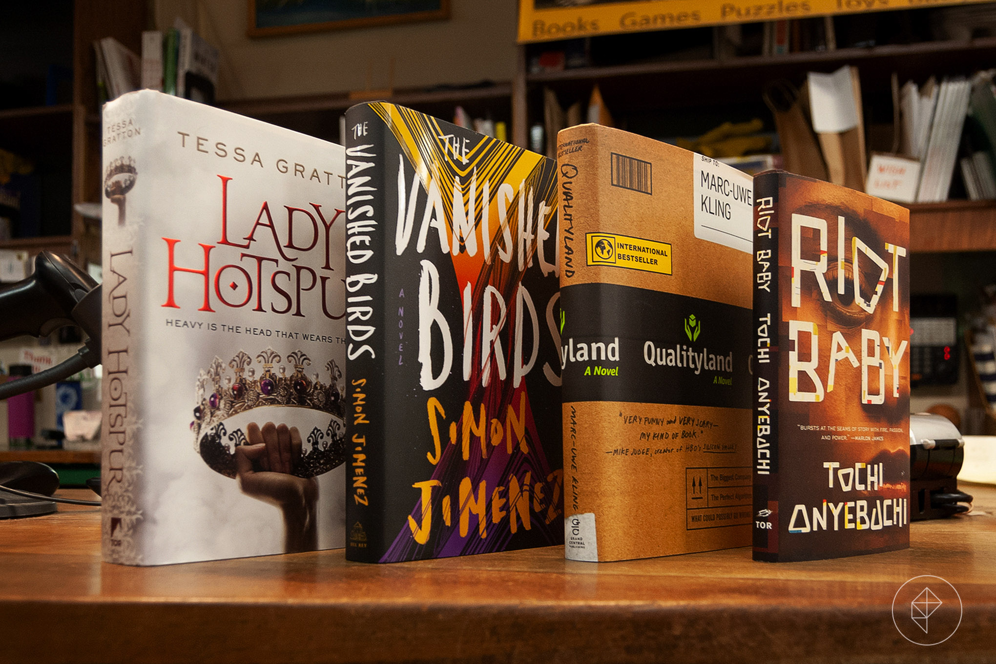 Four books stood upright on a a book store counter
