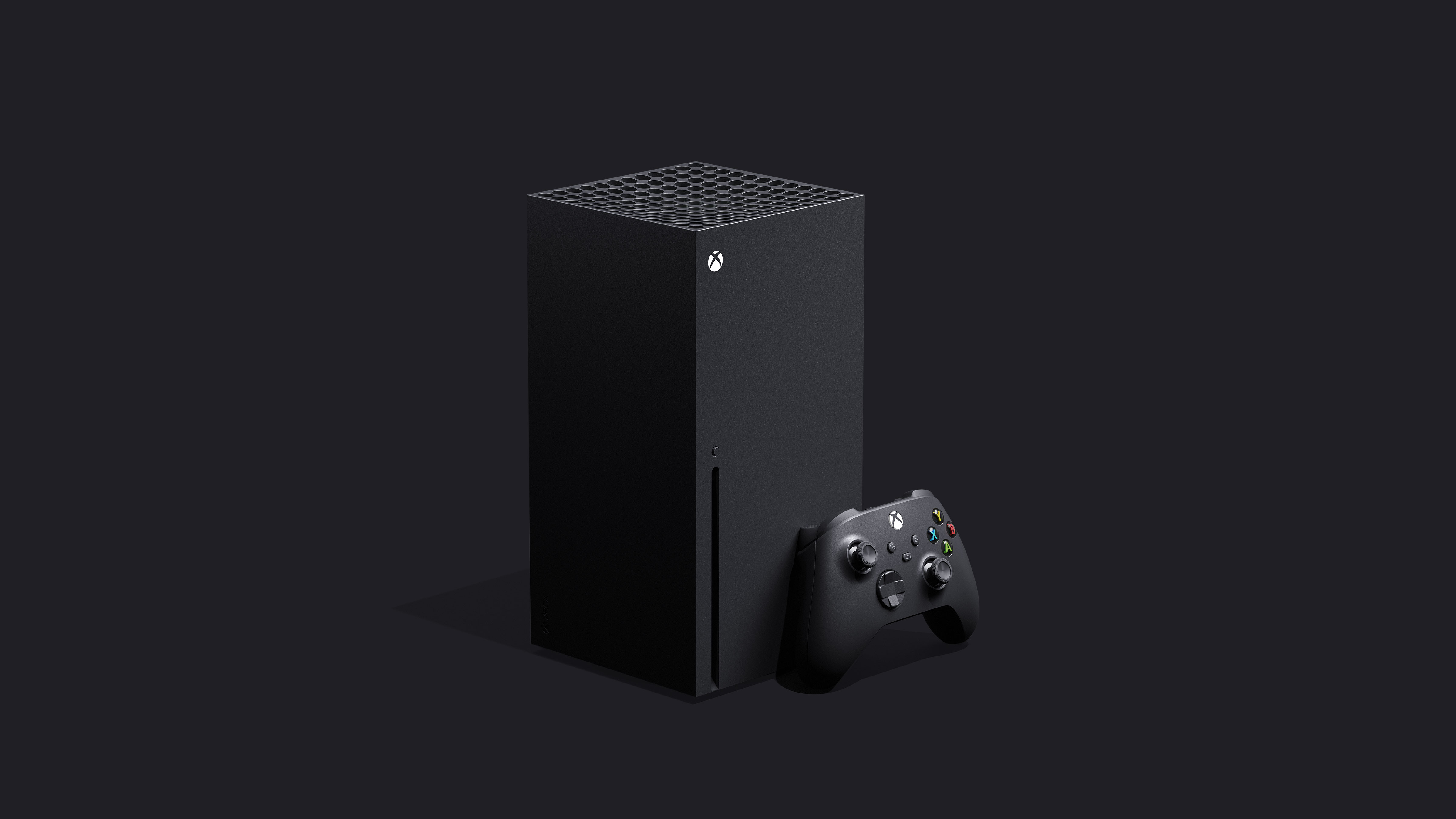 front left angle shot of Xbox Series X with controller standing in front of the console’s bottom right corner