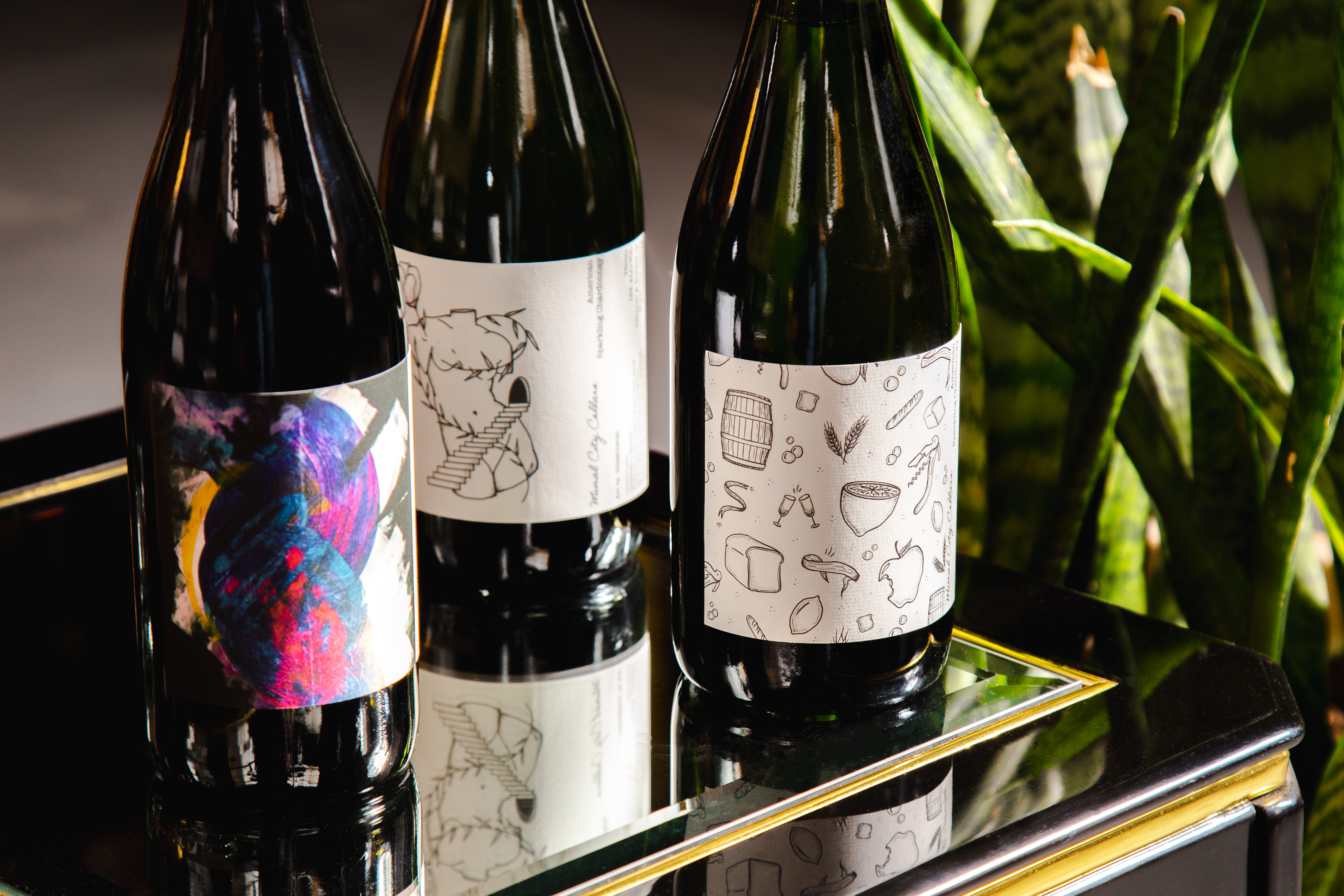 three bottles of wine with illustrations and visual art on the bottles