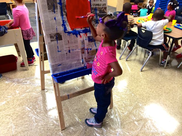 A preschooler at IPS School 102 paints a picture.