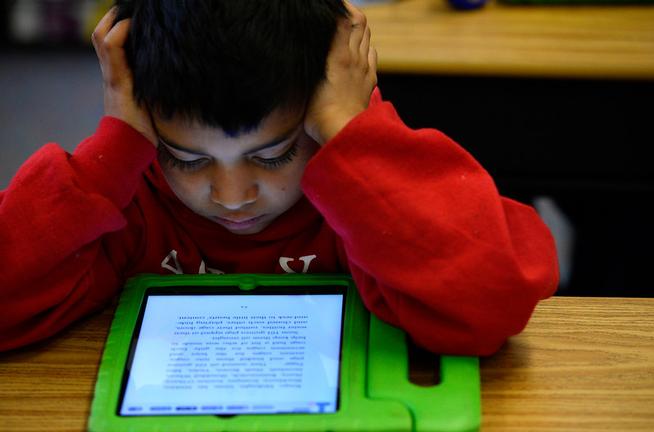 Justin Machado, 9, reads on his iPad during his 3rd grade class  at Ashley Elementary in 2015.