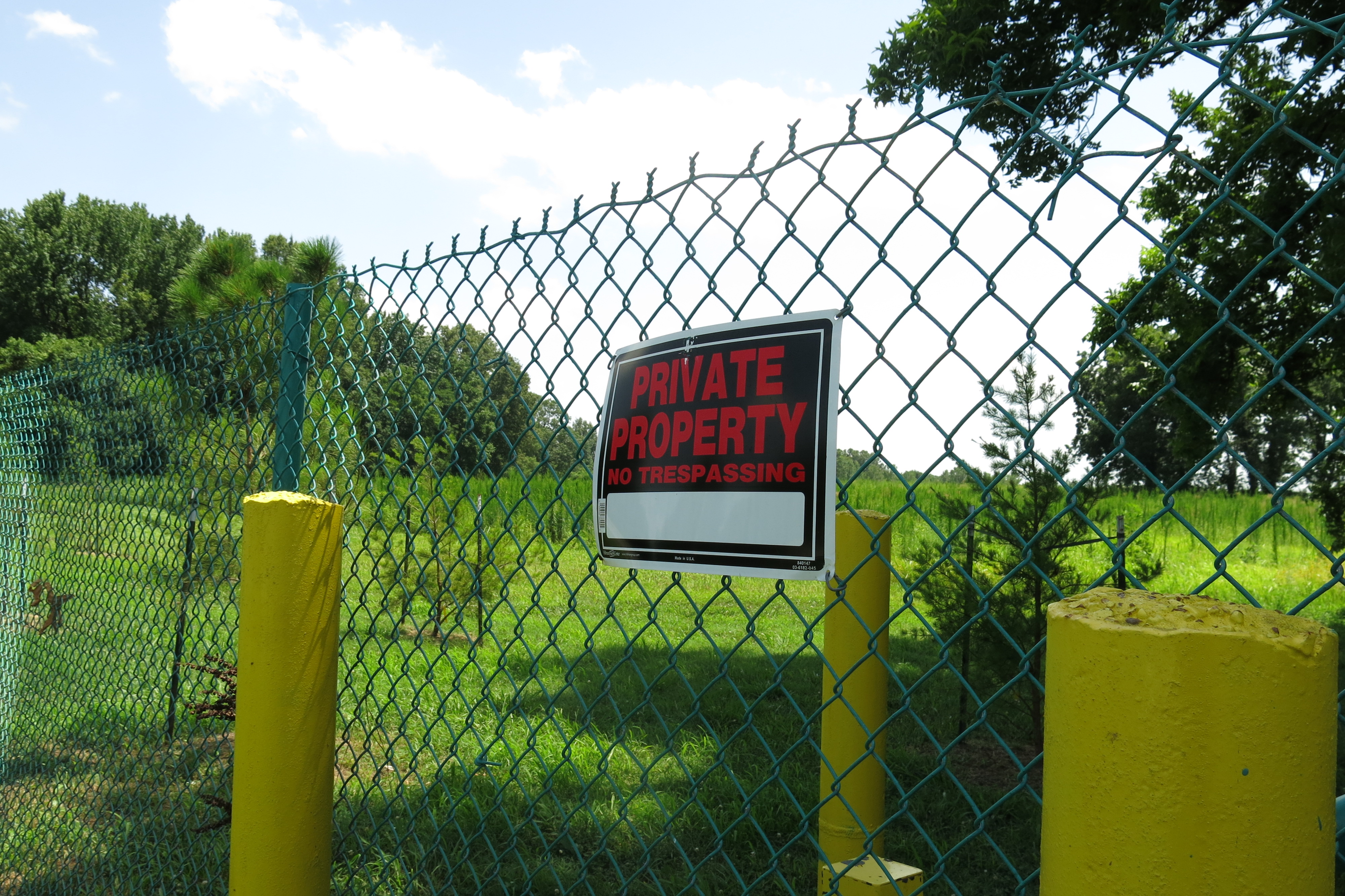 A sign hangs on a fence surrounding the property where a proposed landfill expansion would get even closer to a nearby Memphis elementary school.