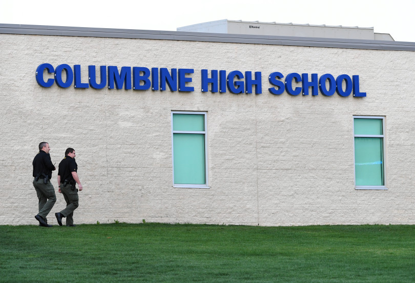 Officers walk around Columbine High School on April 17, 2019, as law enforcement searched for a woman who had traveled from Florida, motivated by an obsession with the 1999 shooting there.
