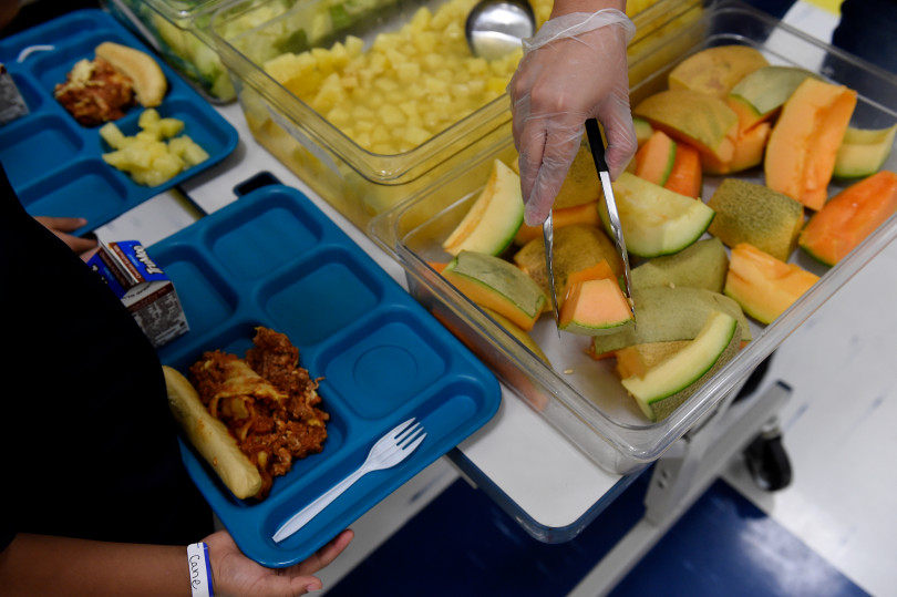 Vanessa Briones serves fruit to first graders during lunch at Laredo Elementary School on August 16, 2017, in Aurora, Colorado.