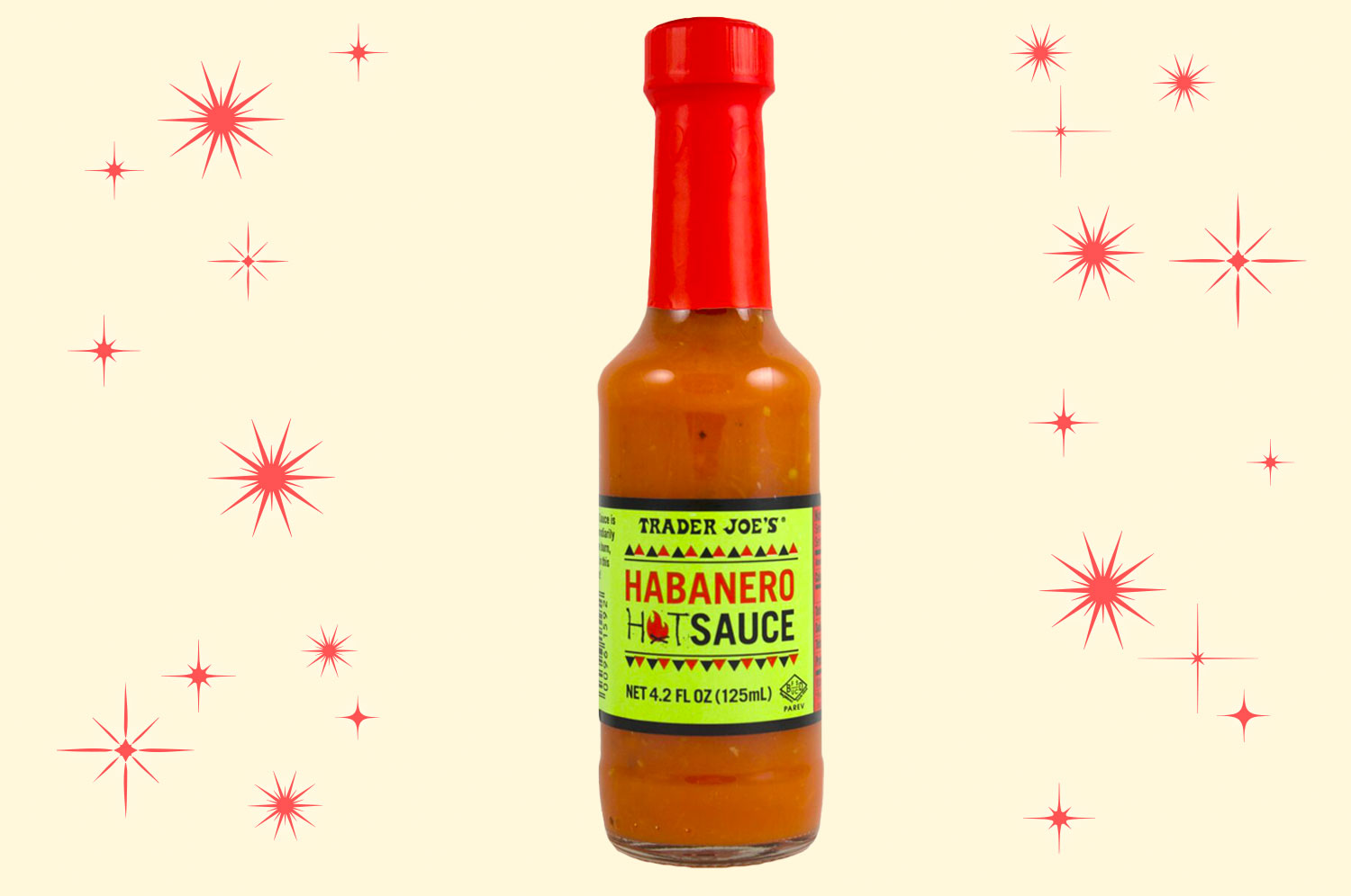 A bottle of Trader Joe’s habanero hot sauce with a fluorescent green label and a red cap floating on an illustrated salmon-colored background with red, mid-century star bursts.