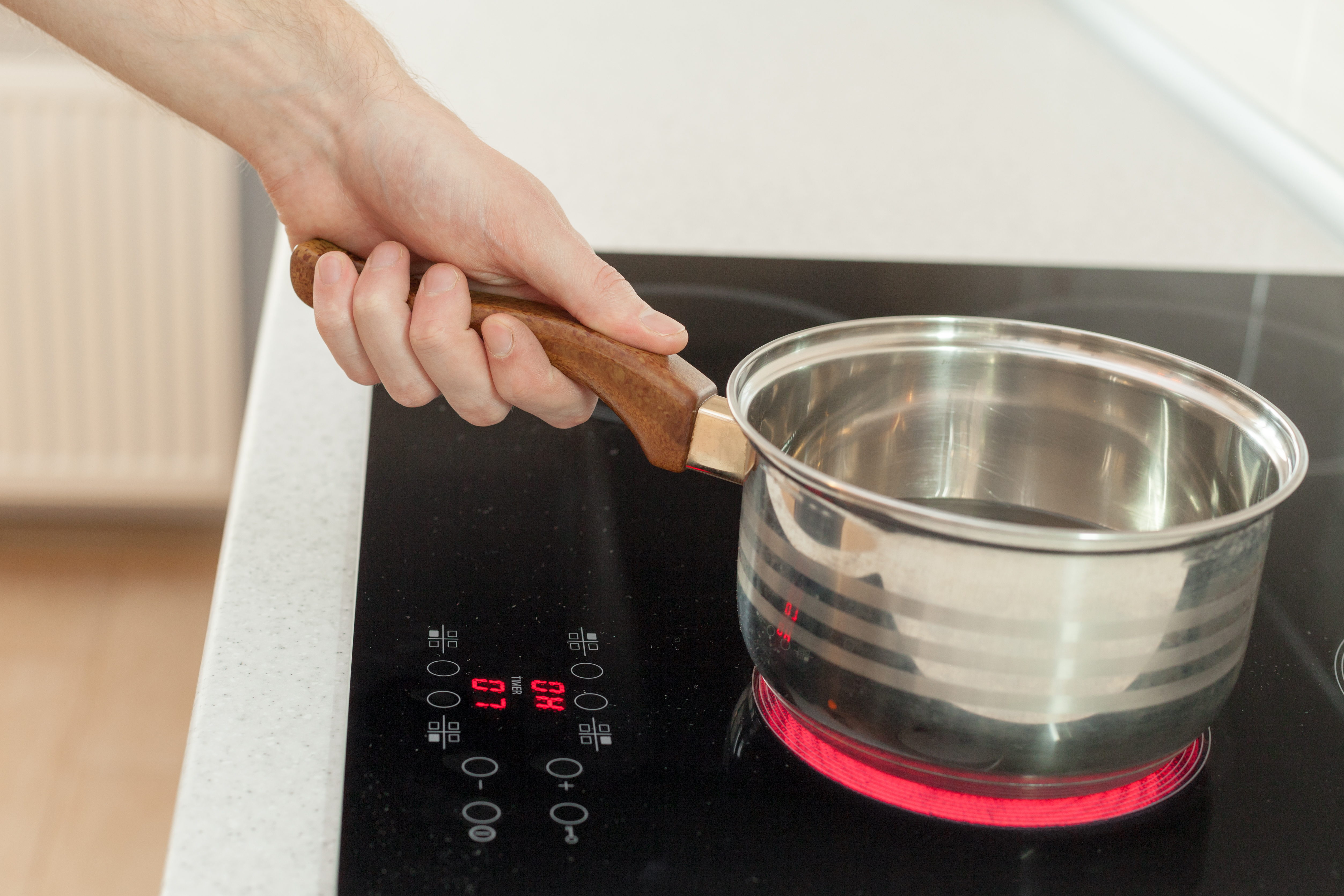 A saucepan on an electric induction stove in a new, modern kitchen.