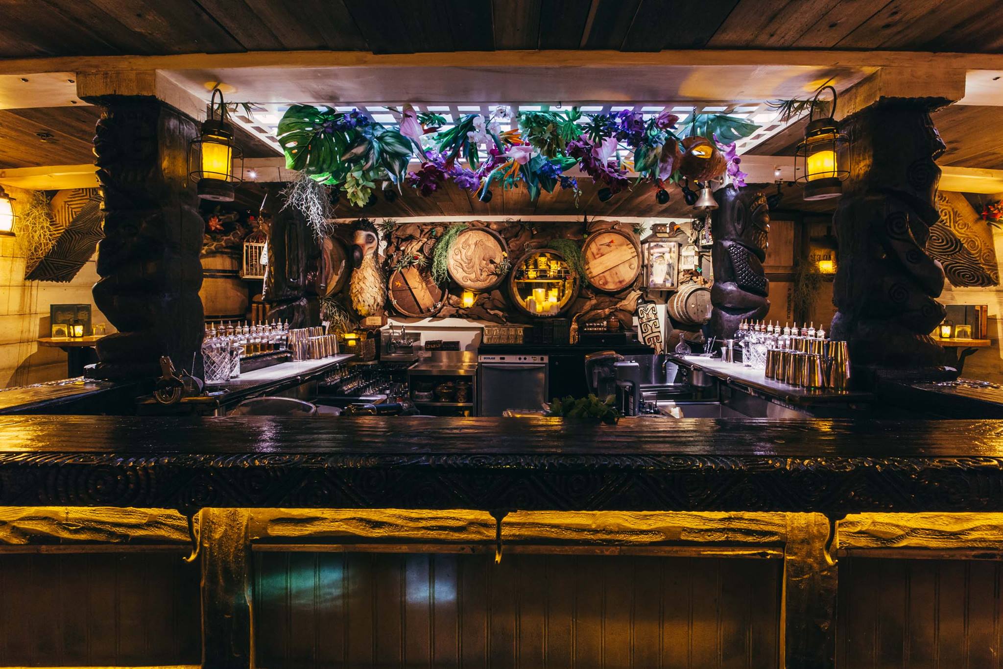 The bar at Undertow, with plants hanging from the ceiling and barrel designs in the background.