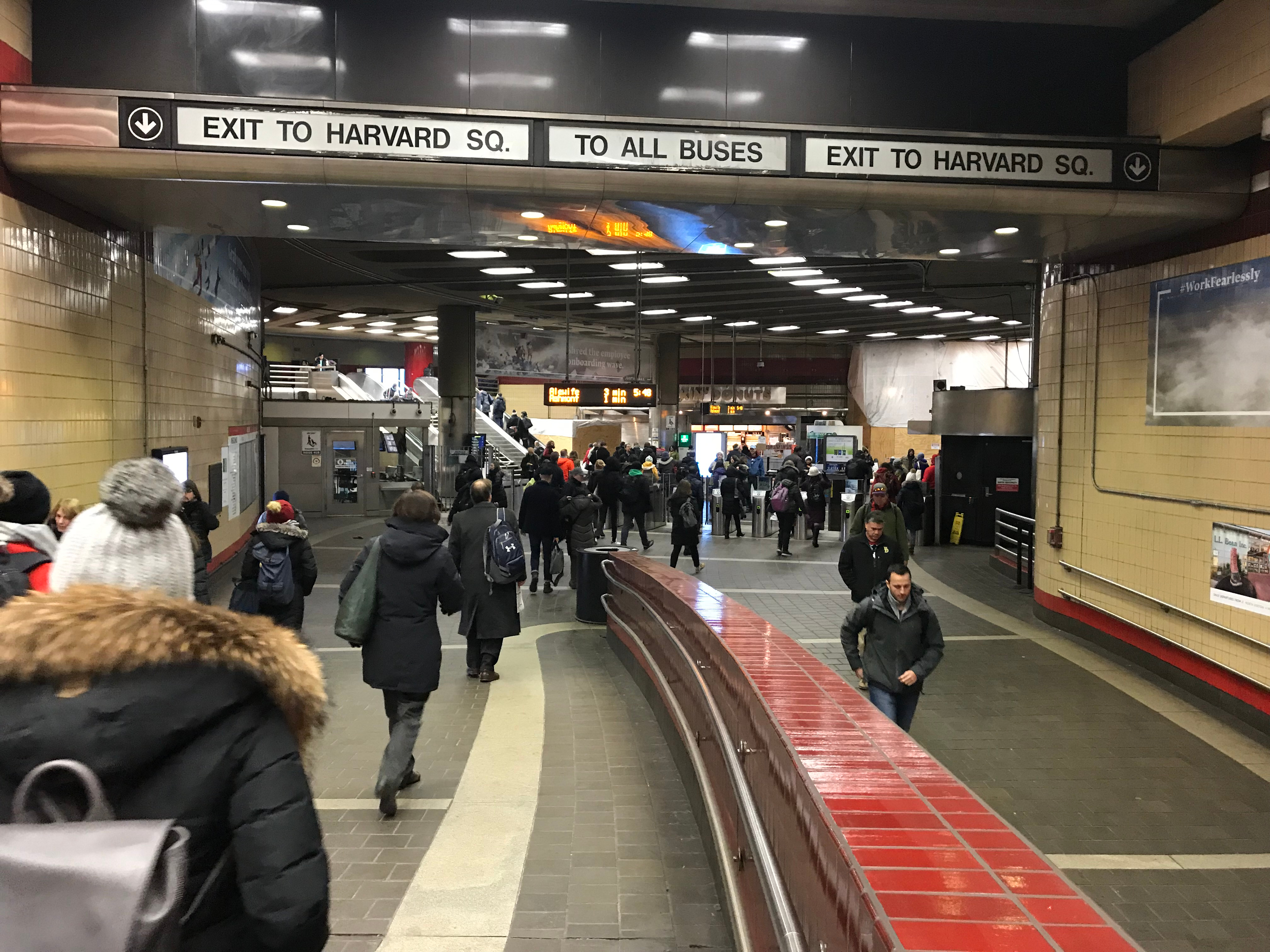 A busy subway station with people walking in different directions toward outgoing and incoming train lines.