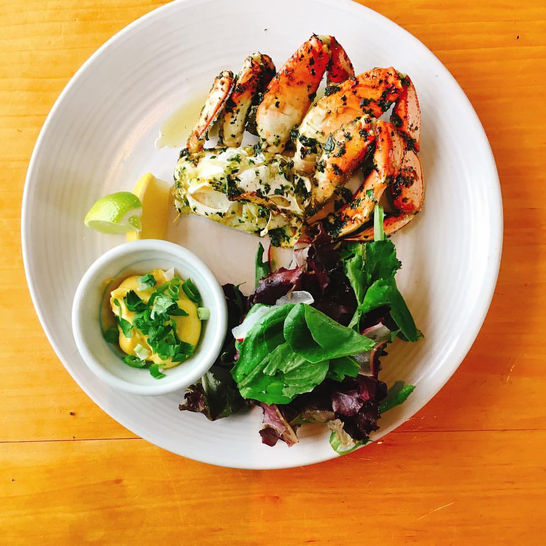 Wood-oven-roasted half Dungeness crab on a white plate