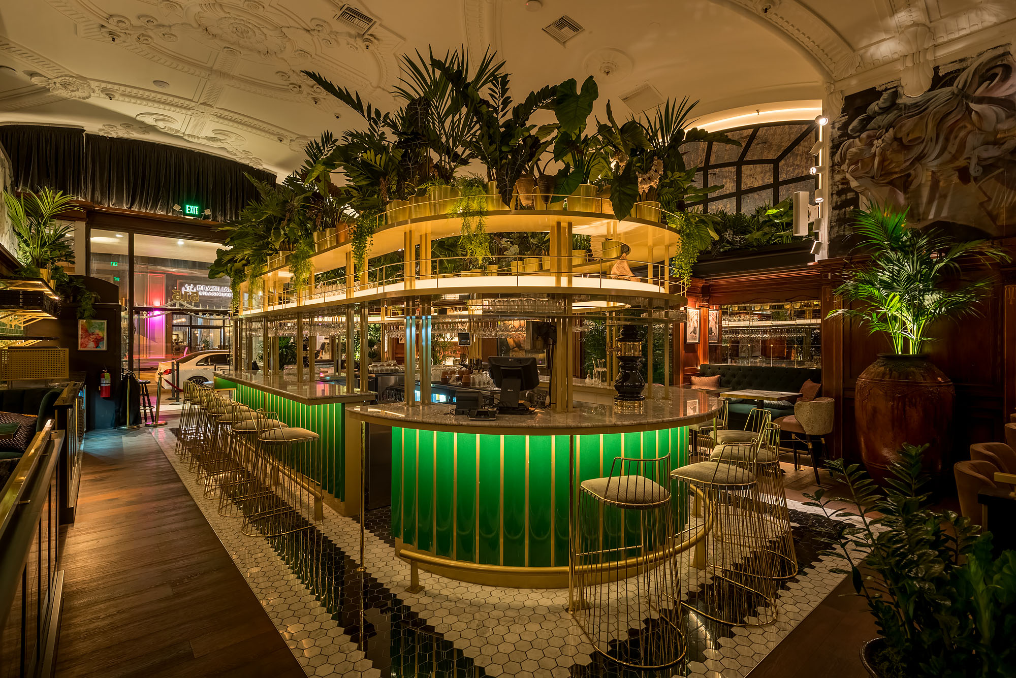 A bright green wraparound bar layered with greenery on top and gold touches.