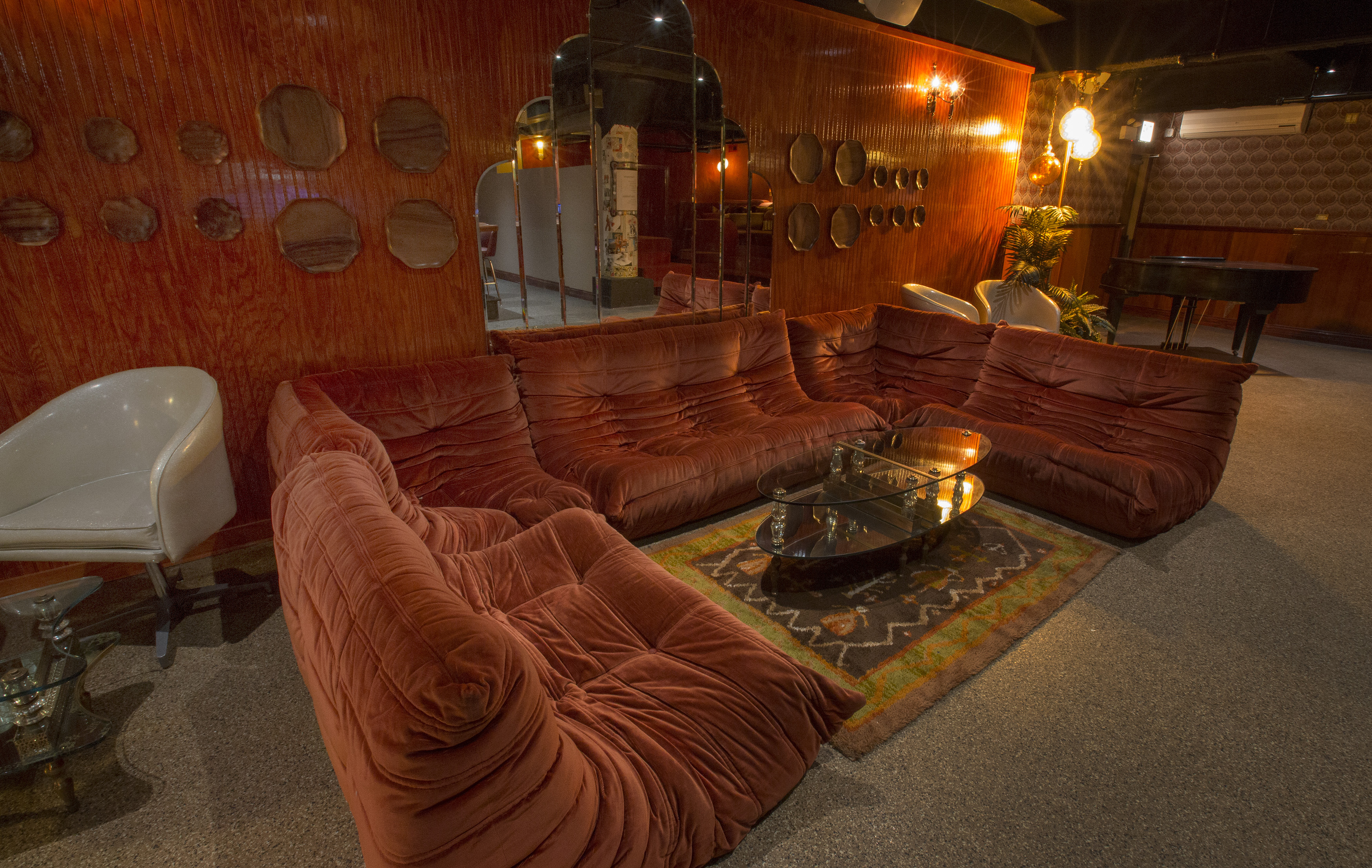 Couch seating with low tables in a basement bar.