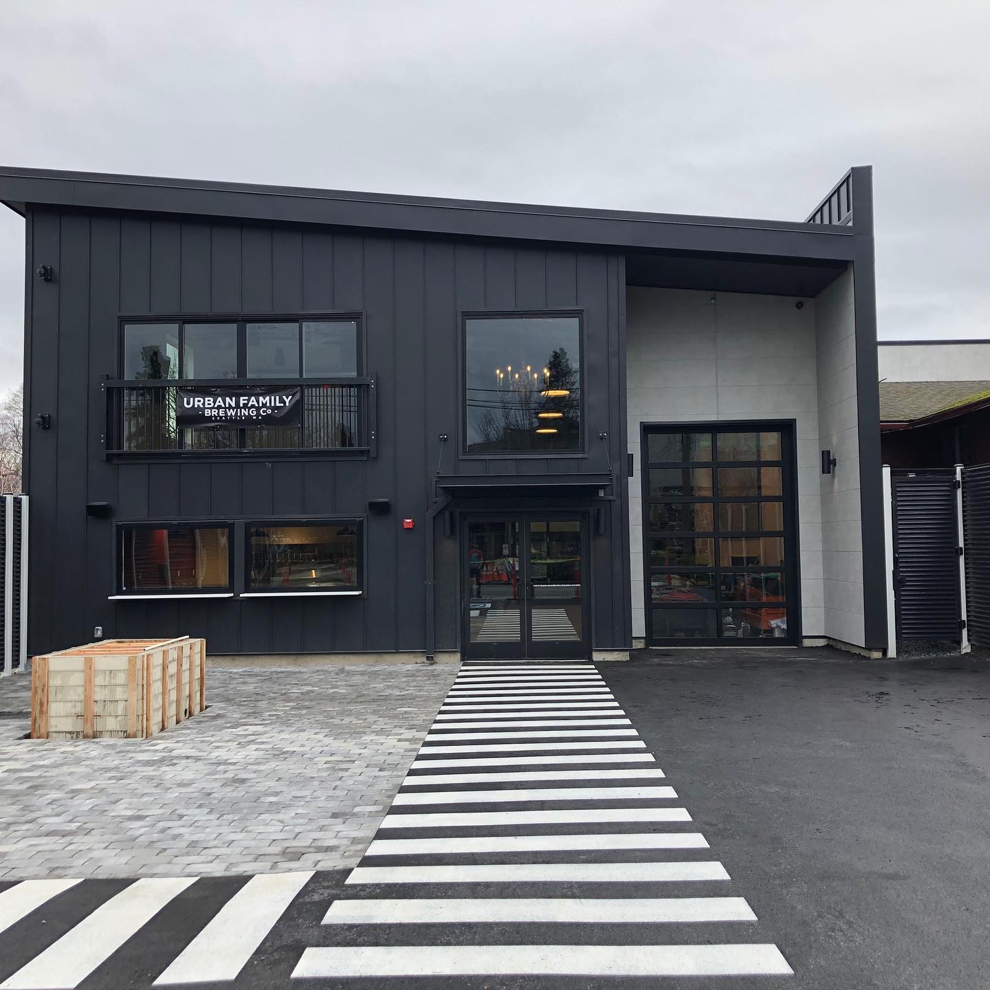The outside of Urban Family Brewing’s new Ballard taproom with gray tones and a slanted roof.