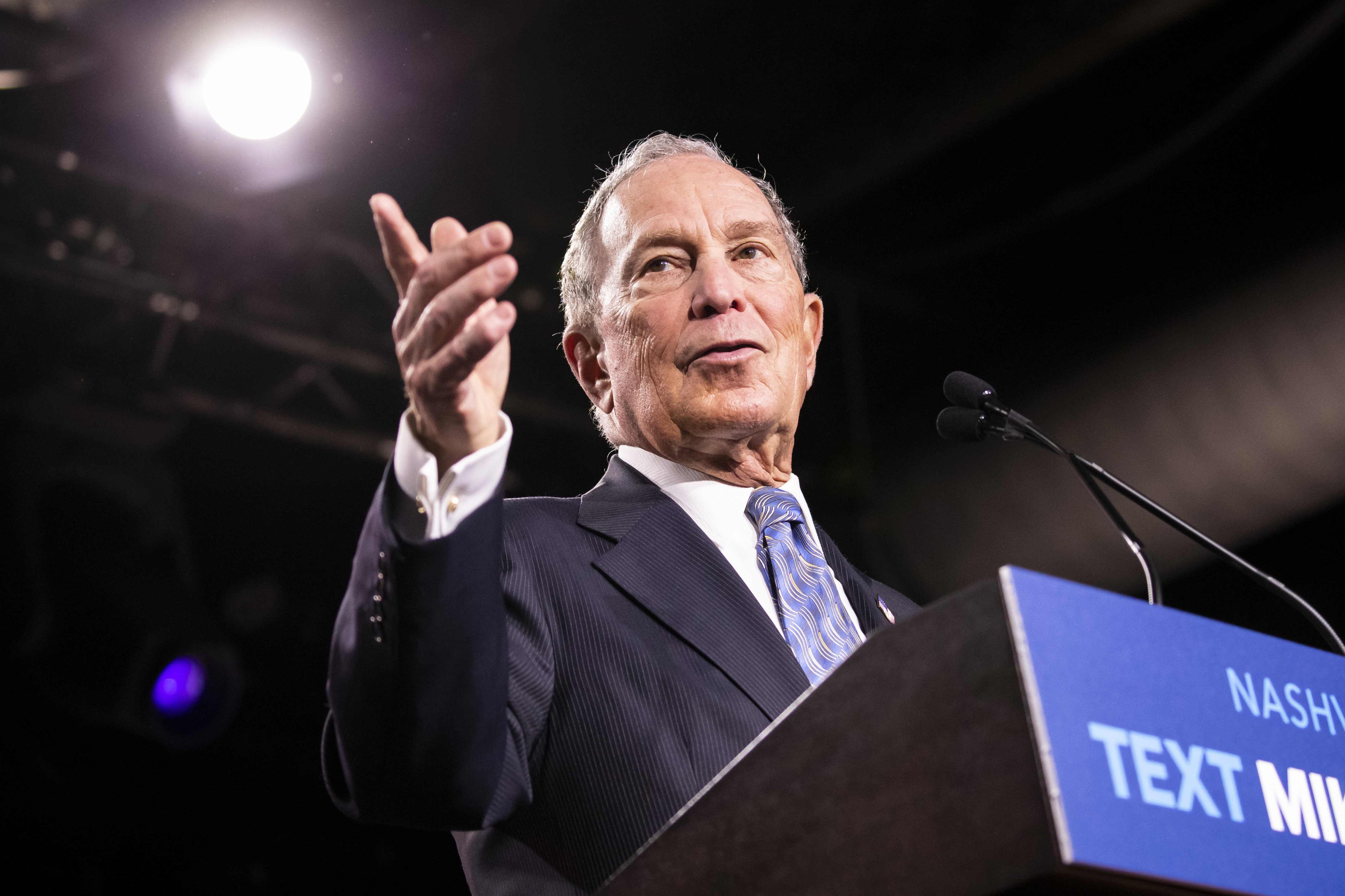 Mike Bloomberg speaking from a podium on the campaign trail.