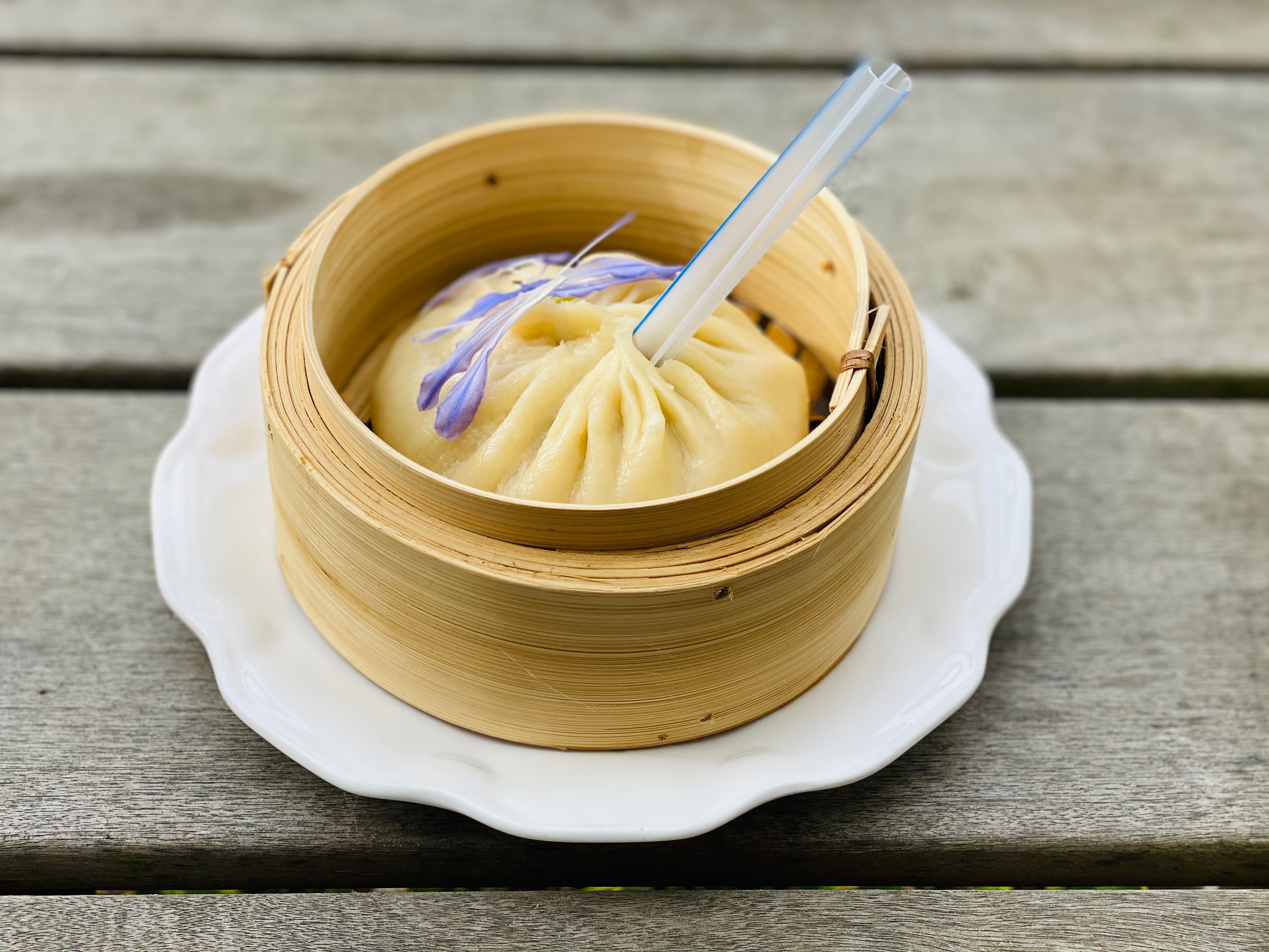 A jumbo-size soup dumpling, served with a straw