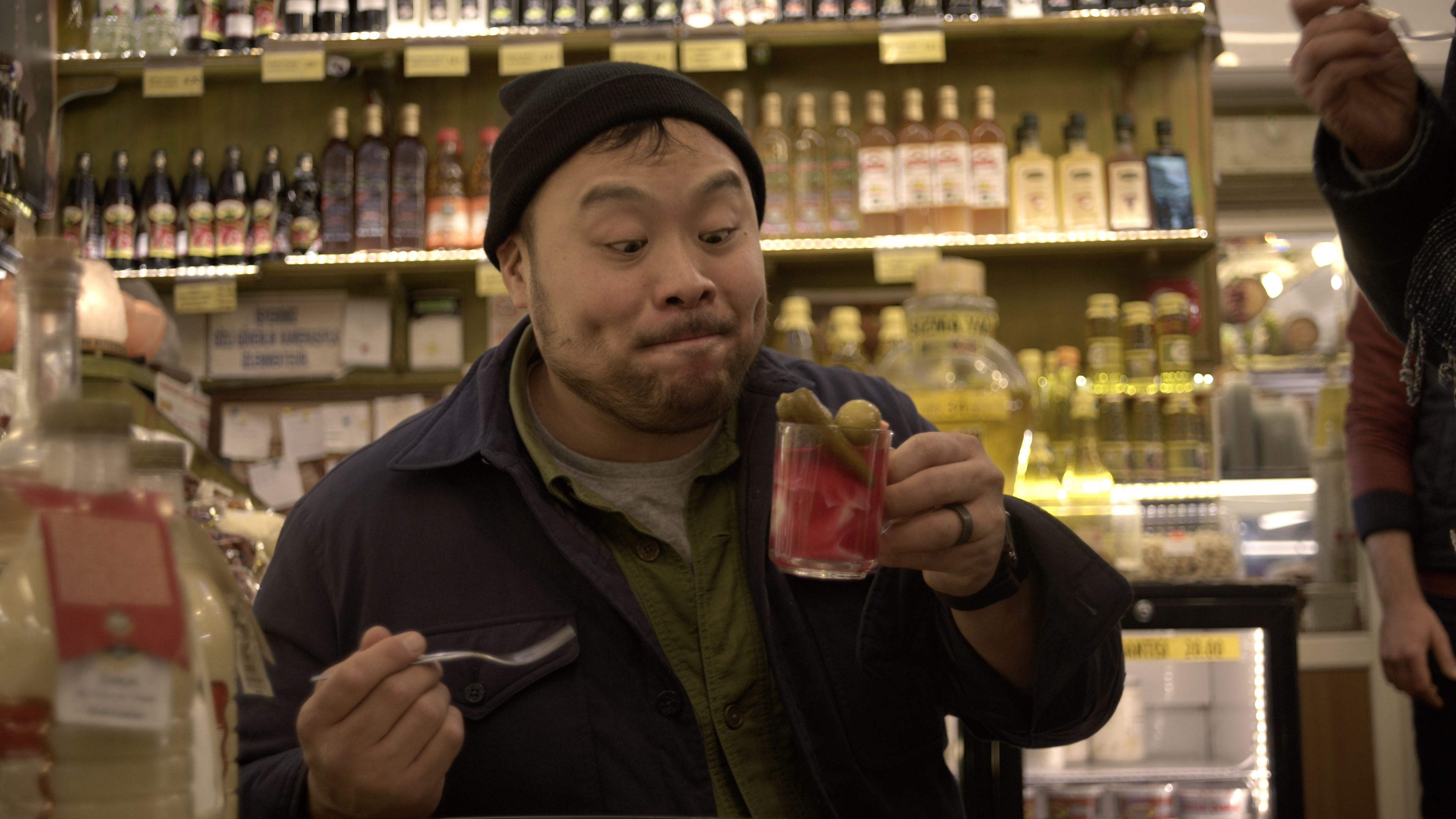 David Chang making a goofy face at a glass of pickle juice.