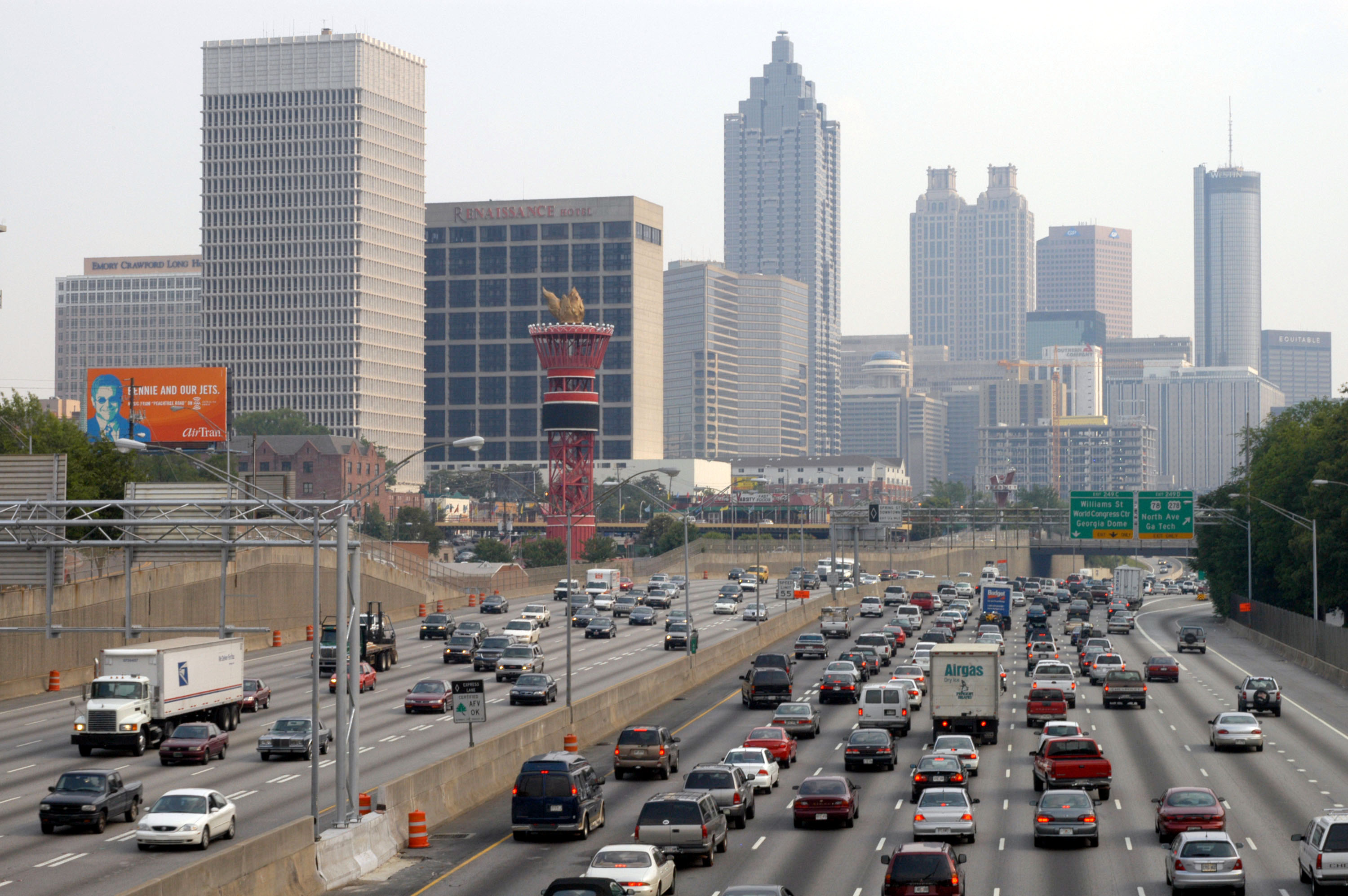 A picture of atlanta traffic, with cars in the foreground and buildings behind.