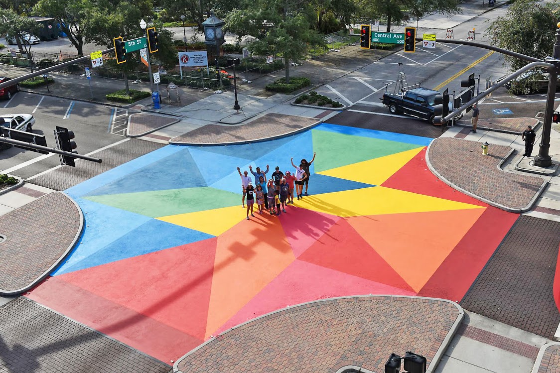 An aerial view of a street intersection painted in bright colors like blue, yellow, and red. 