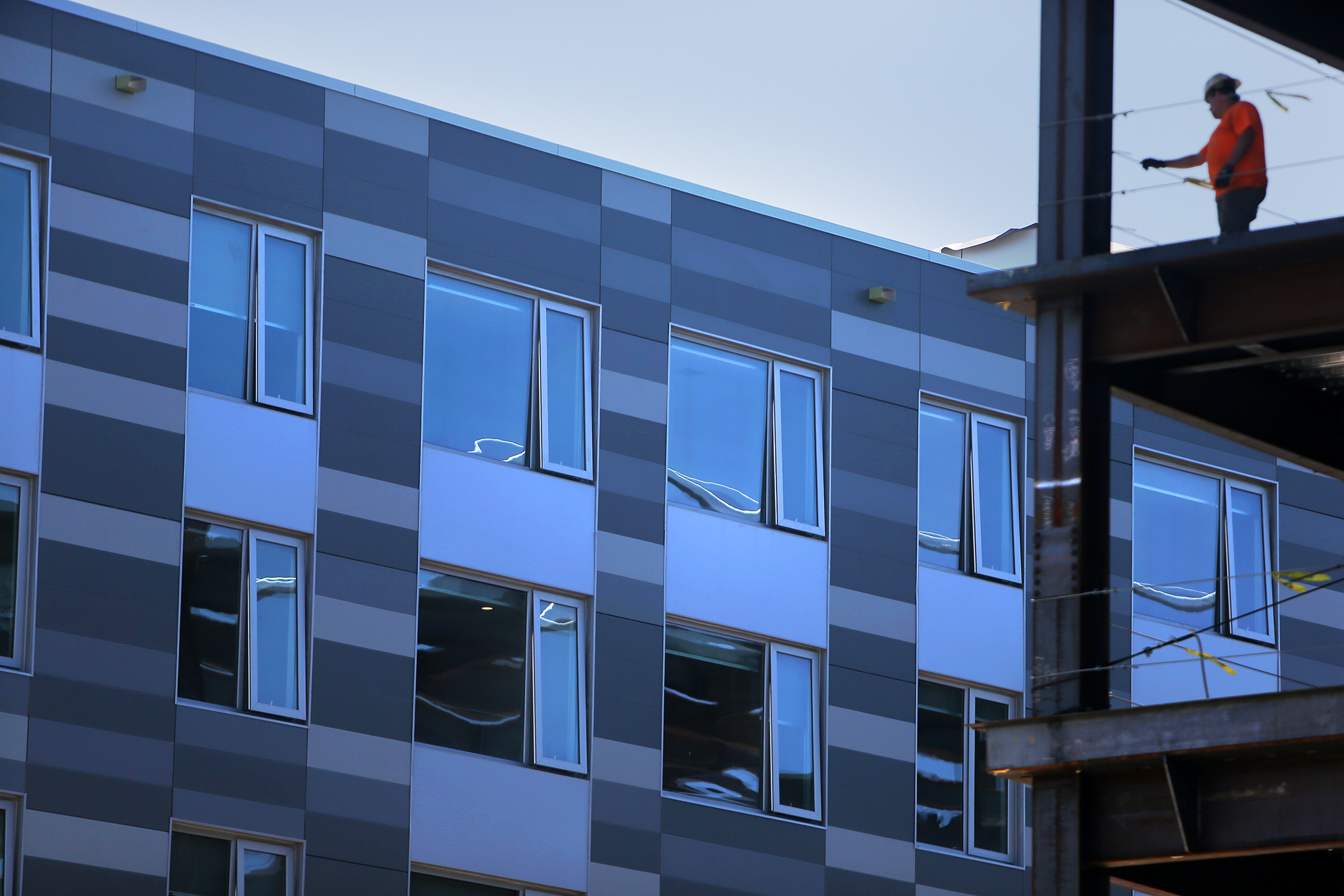 A block of newly built apartments up close, with the new windows slightly open.