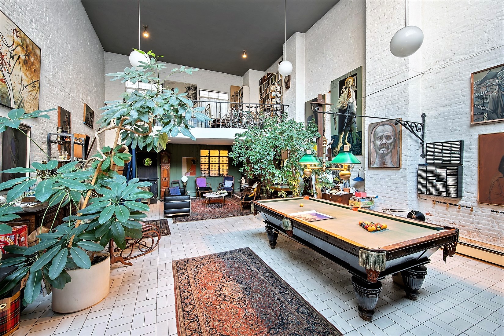 A open living area with 20-foot ceilings, a pool table, and a large skylight.
