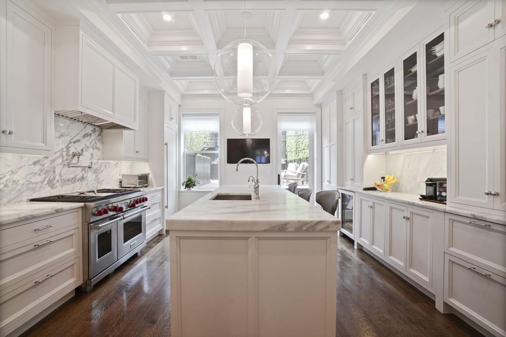 A spacious kitchen with two ovens and a large marble island. 