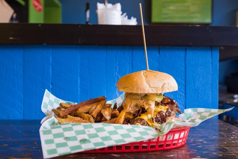 A picture of a burger smothered in bacon, cheese, peanut butter, and pineapple habanero chutney at Stoopid Burger
