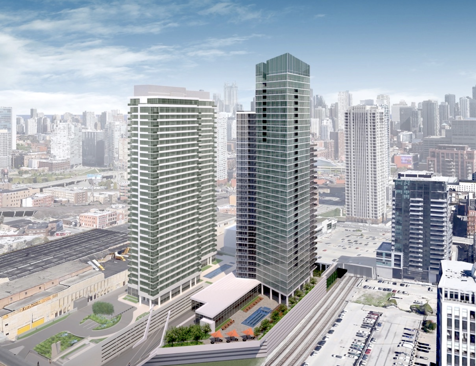 A rendering showing a glassy high-rise tower with an angled crown next to a shorter high-rise. The buildings stand next to train tracks and tall buildings stand in a row in the distance. 