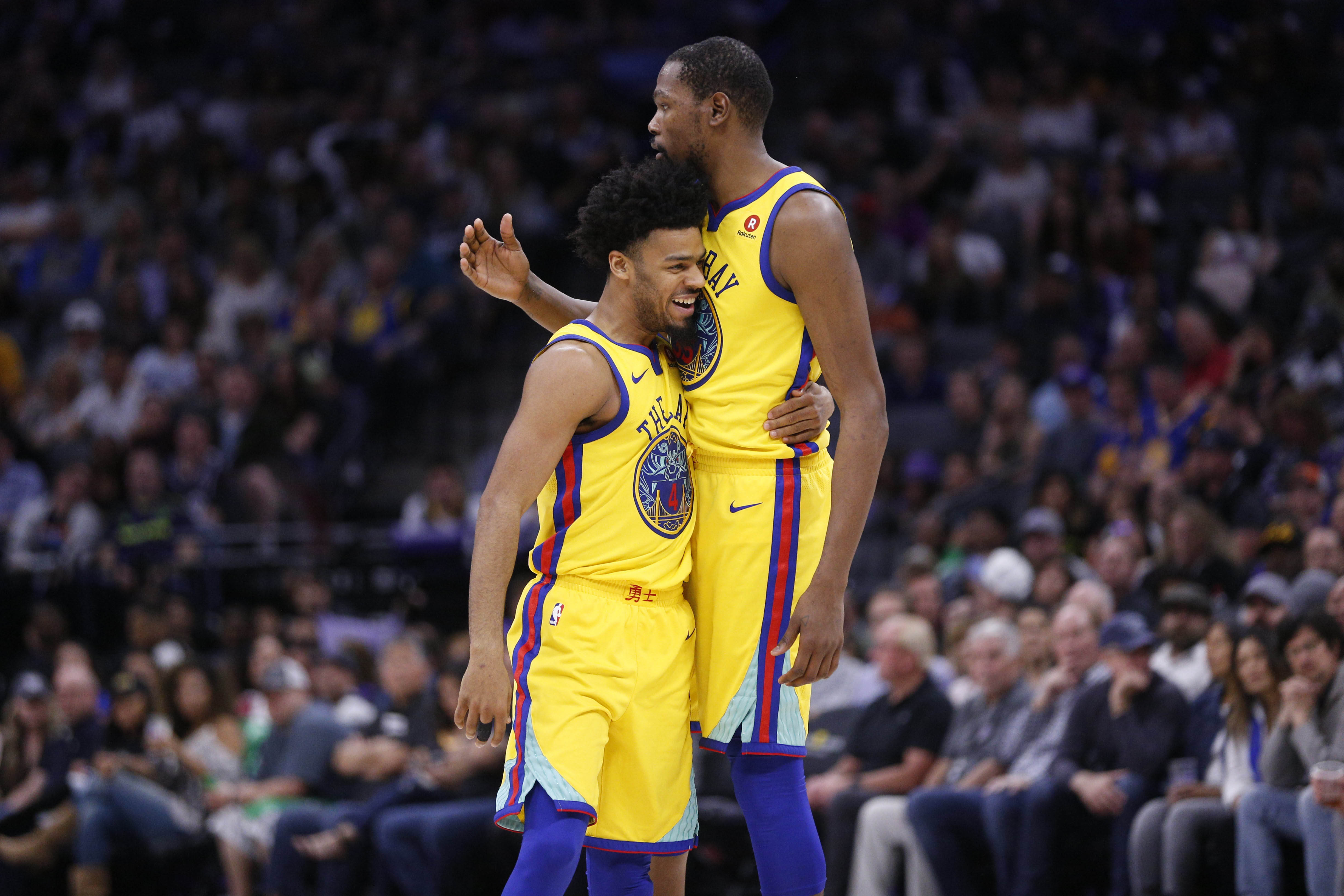 Mar 31, 2018; Sacramento, CA, USA; Golden State Warriors guard Quinn Cook (4) hugs forward Kevin Durant (35) after making a shot against the Sacramento Kings near the end of the third quarter at the Golden 1 Center.
