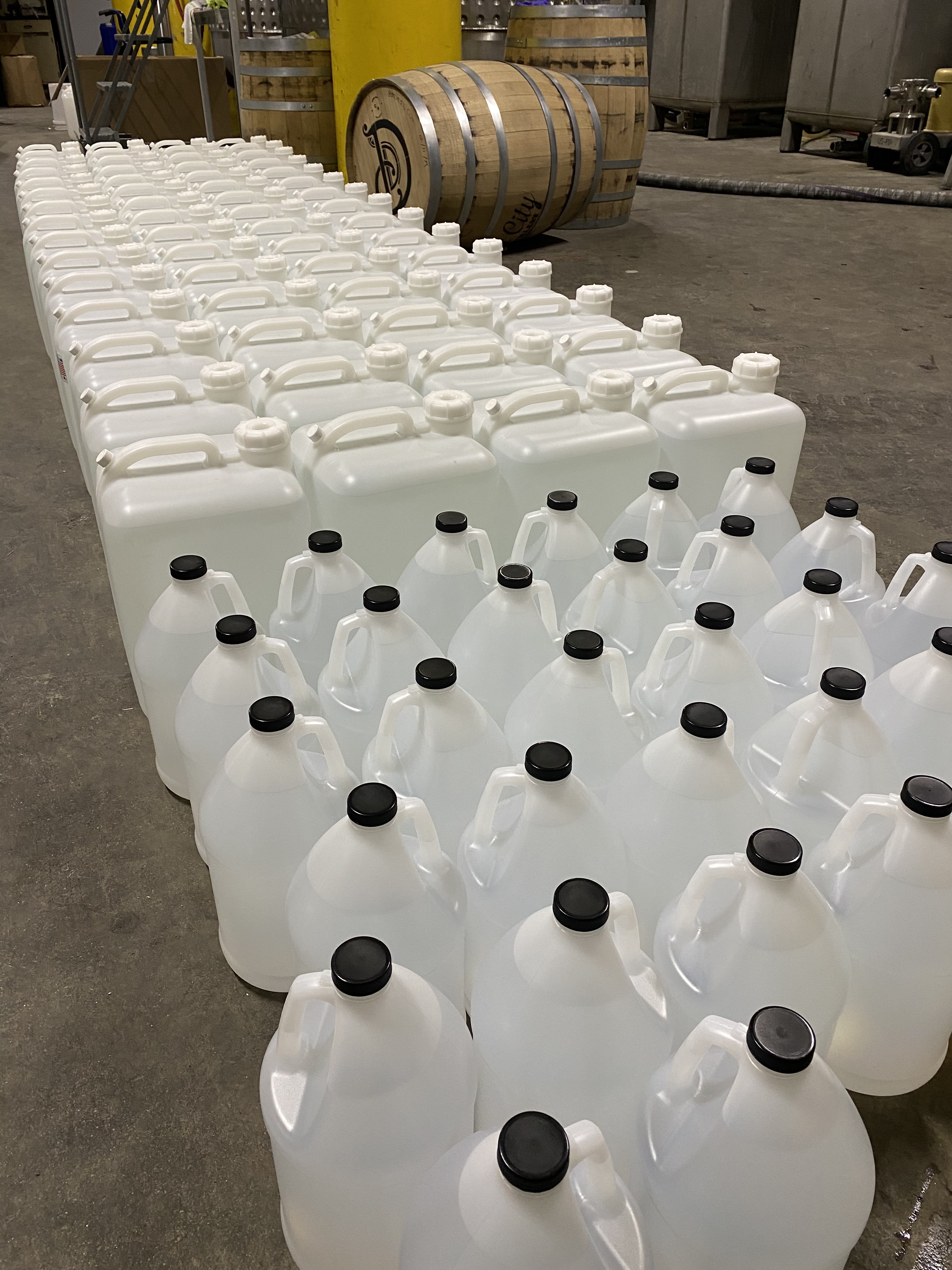 Clear jugs sit on the floor at Detroit City Distillery production facility. 