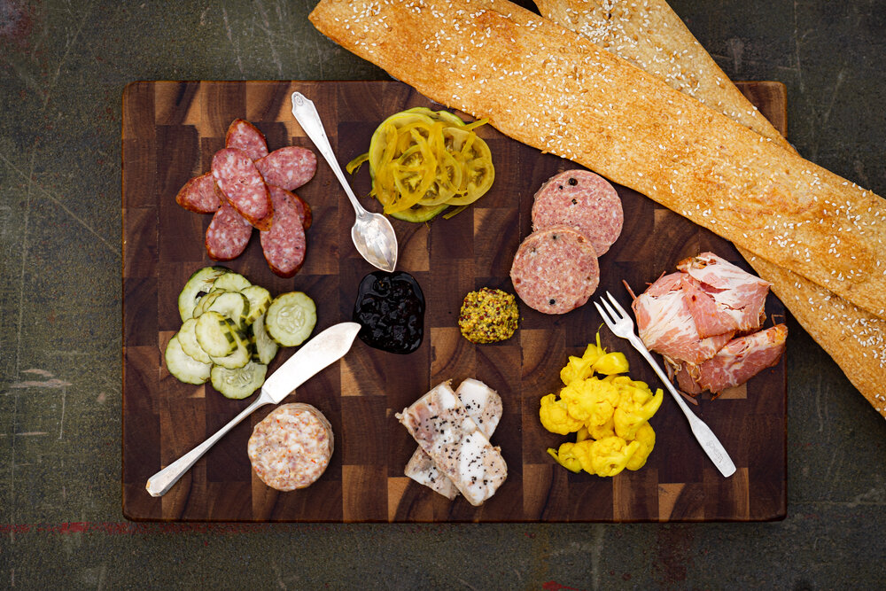 Charcuterie platter with garnishes and metal spoons from Persepshen