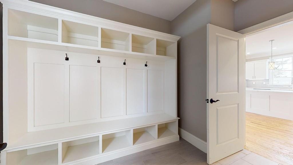 A walk-in closet with hooks and cabinetry.